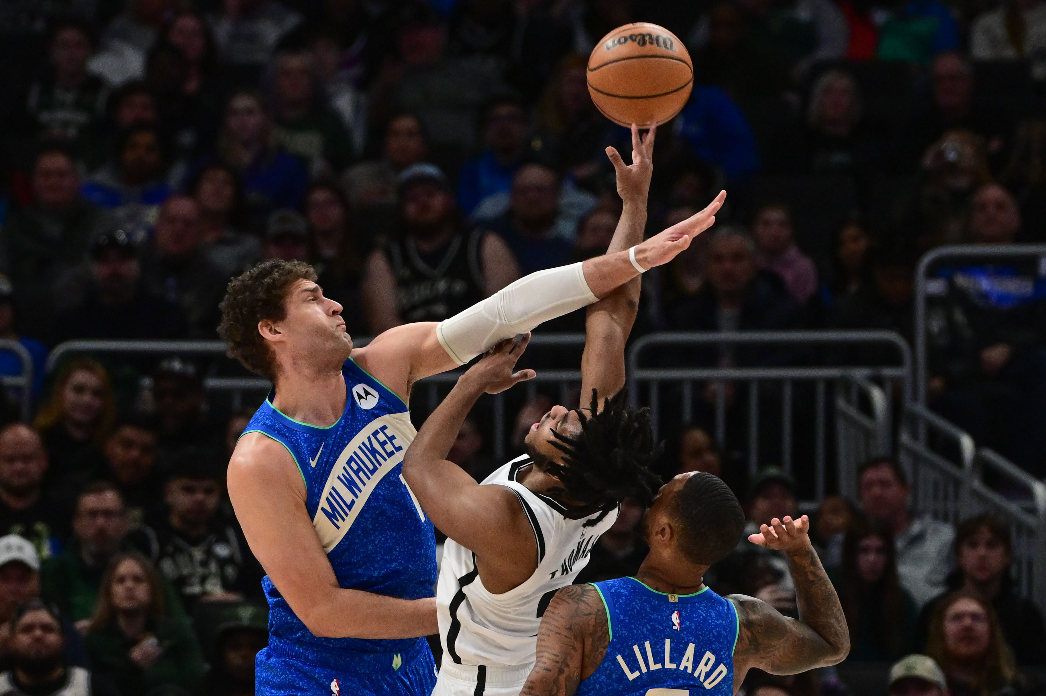 Milwaukee Bucks center Brook Lopez tries to block a shot by Brooklyn Nets guard Cameron Thomas at Fiserv Forum. Photo Credit: Imagn