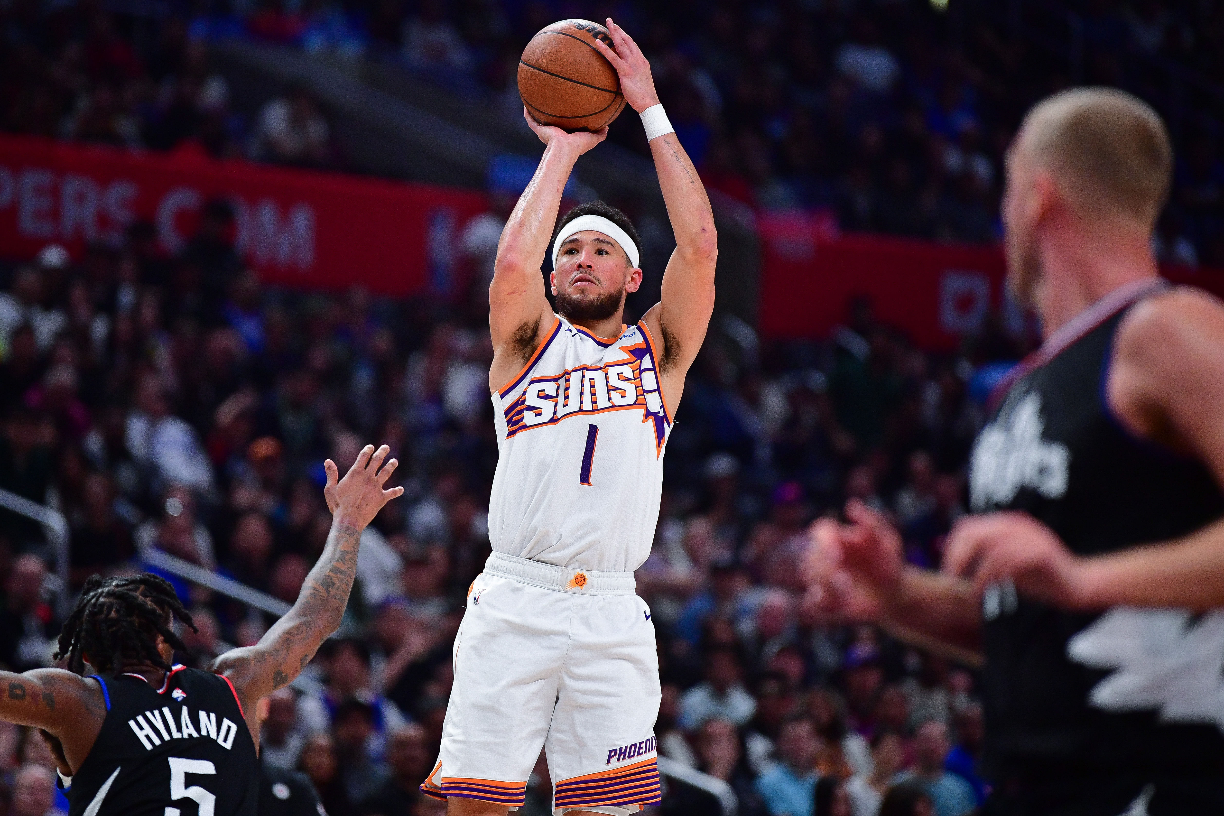 Phoenix Suns guard Devin Booker shoots against Los Angeles Clippers guard Bones Hyland at Crypto.com Arena. Photo Credit: Imagn