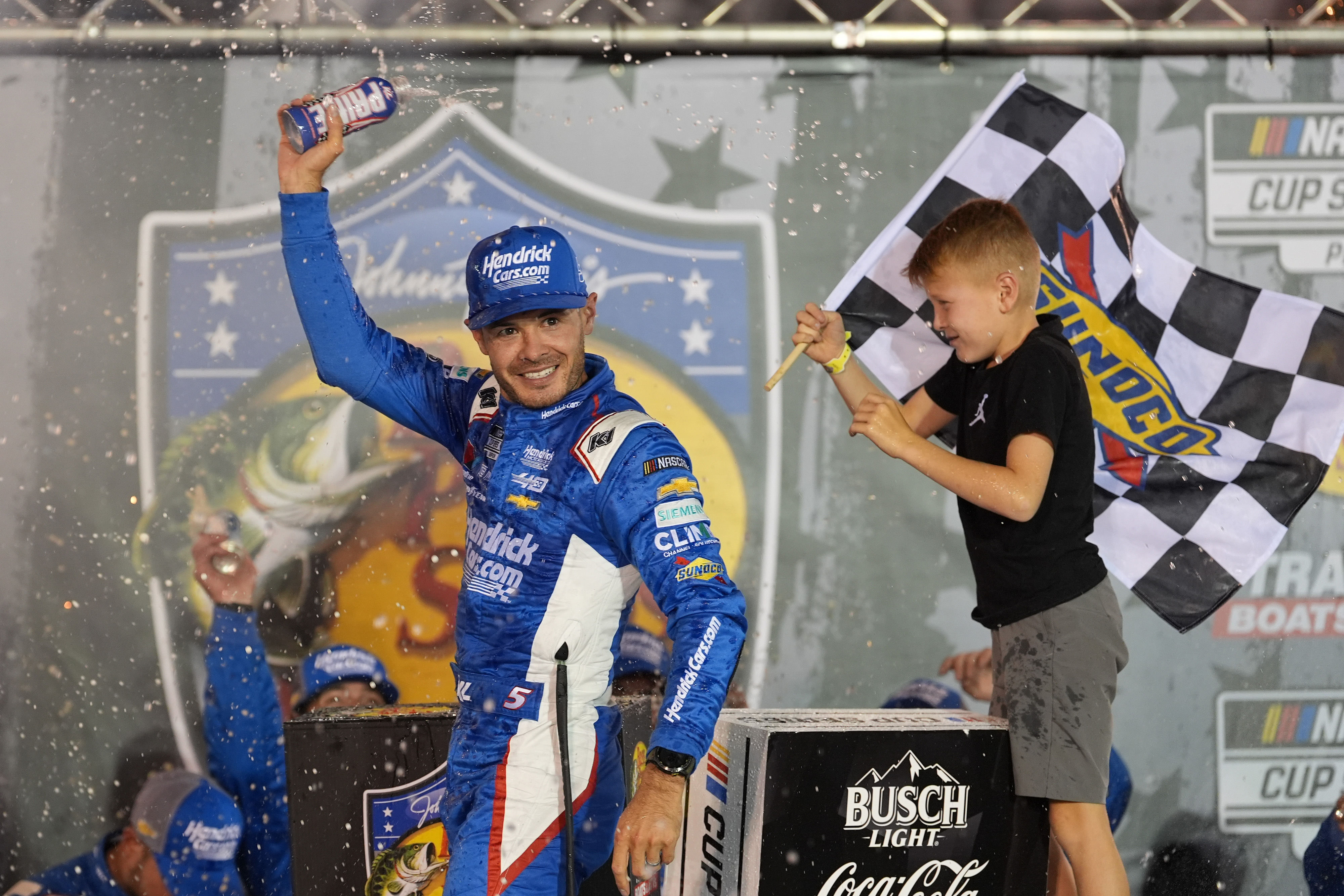 Kyle Larson (5) and his son Owen after winning the Bass Pro Shops Night Race at Bristol Motor Speedway. (Image via Imagn Images)