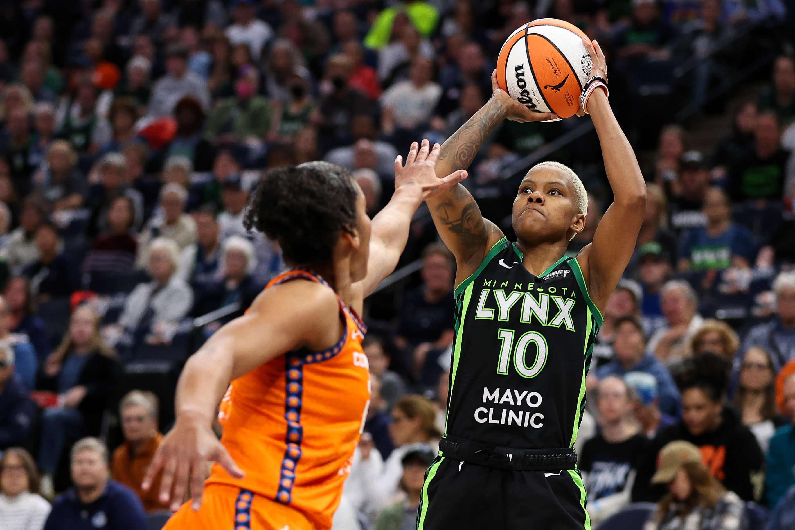 Minnesota Lynx guard Courtney Williams shoots as Connecticut Sun forward Alyssa Thomas defends at Target Center. Photo Credit: Imagn