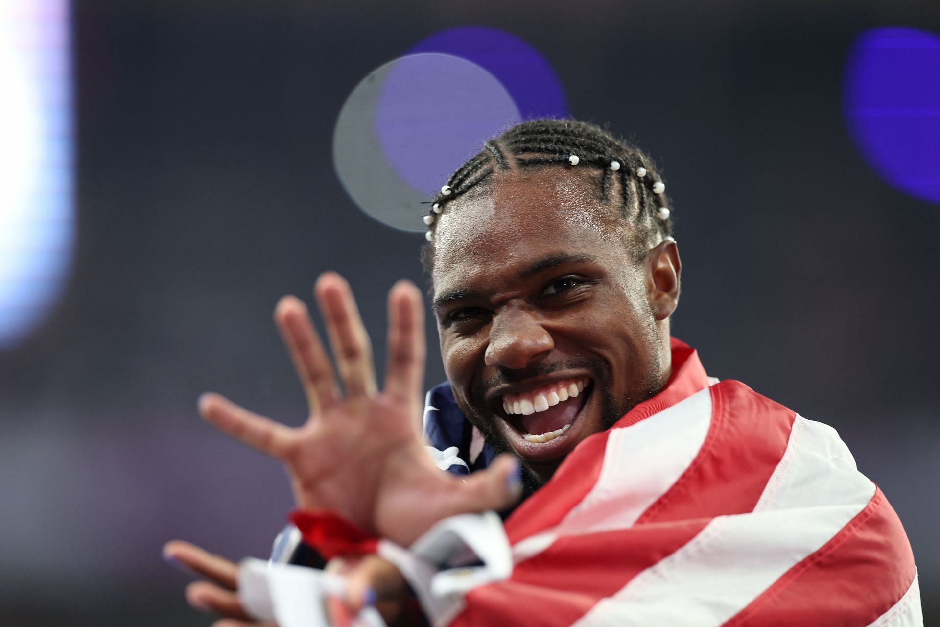 Noah Lyles in action victorious with the American flag after winning the Gold medal in the Men&#039;s 100m final in Paris, France. (Photo via Getty Images)