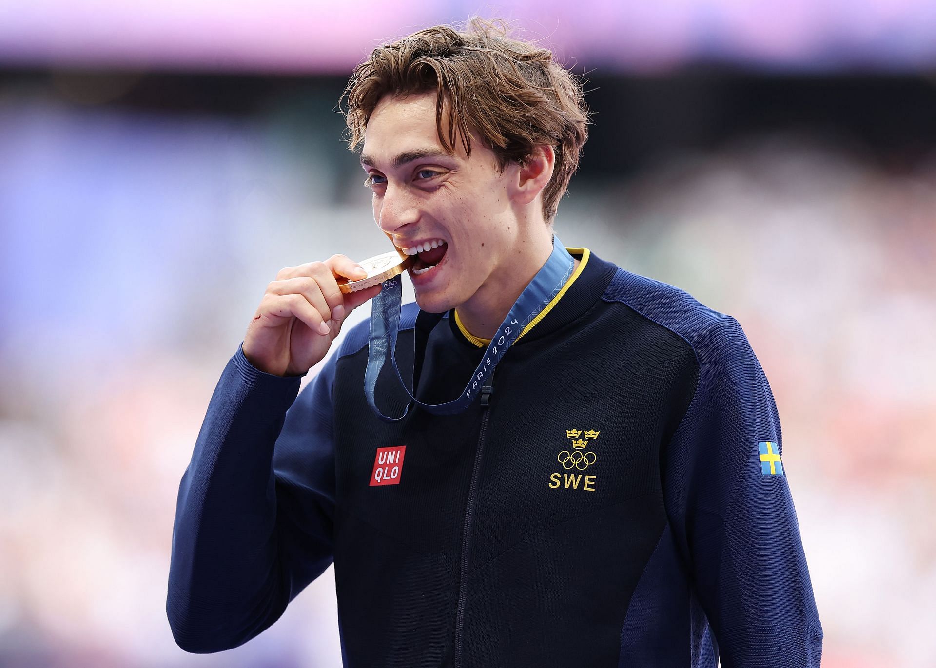 Mondo Duplantis biting his pole vault gold medal at the Olympic Games Paris 2024: (Source: Getty)