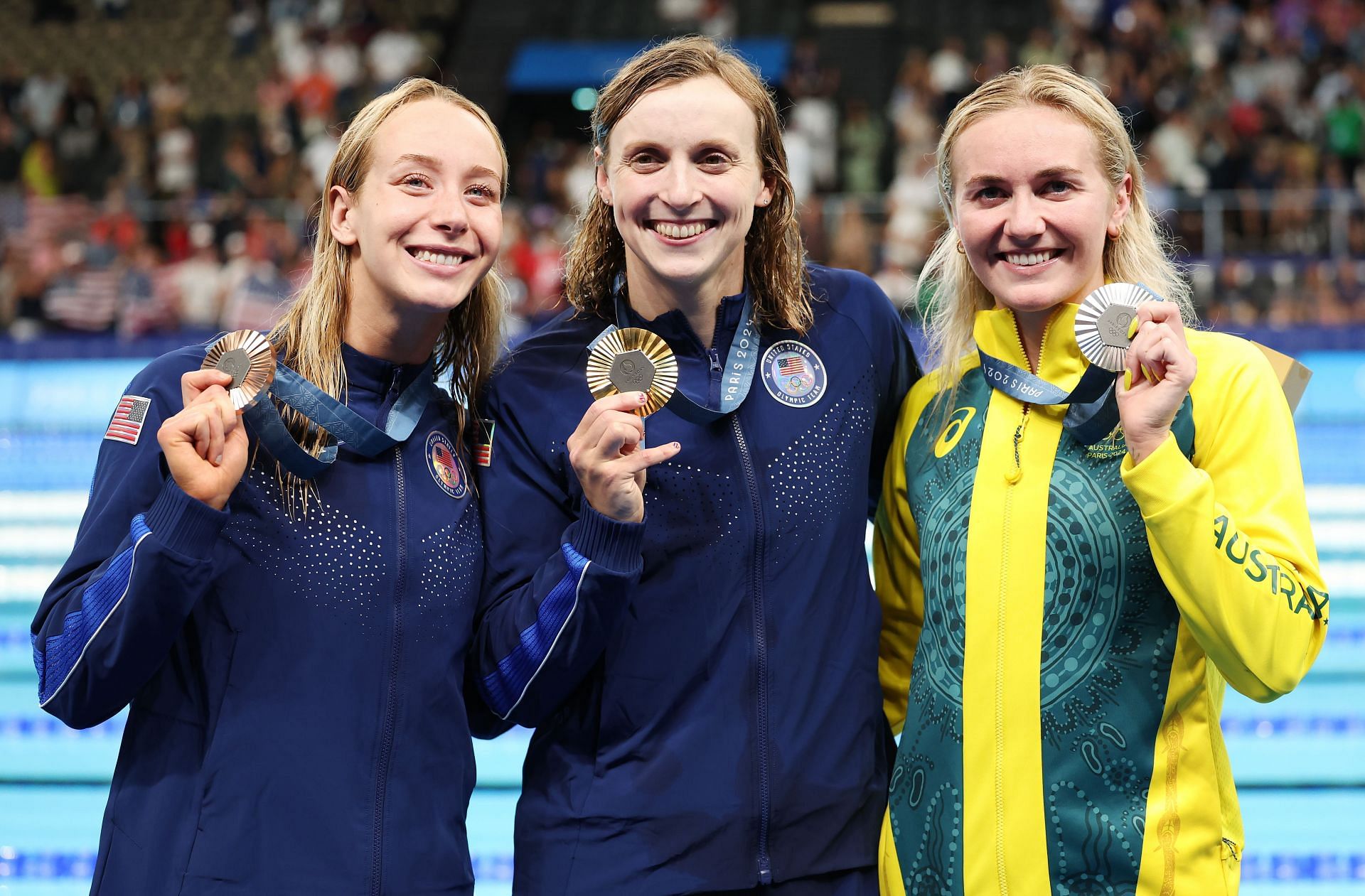 Ariarne Titmus of Australia (R) with Olympic champion Katie Ledecky and bronze medalist Paige Madden of the USA (L) after the victory ceremony for the women&#039;s 800m freestyle event | Getty Images