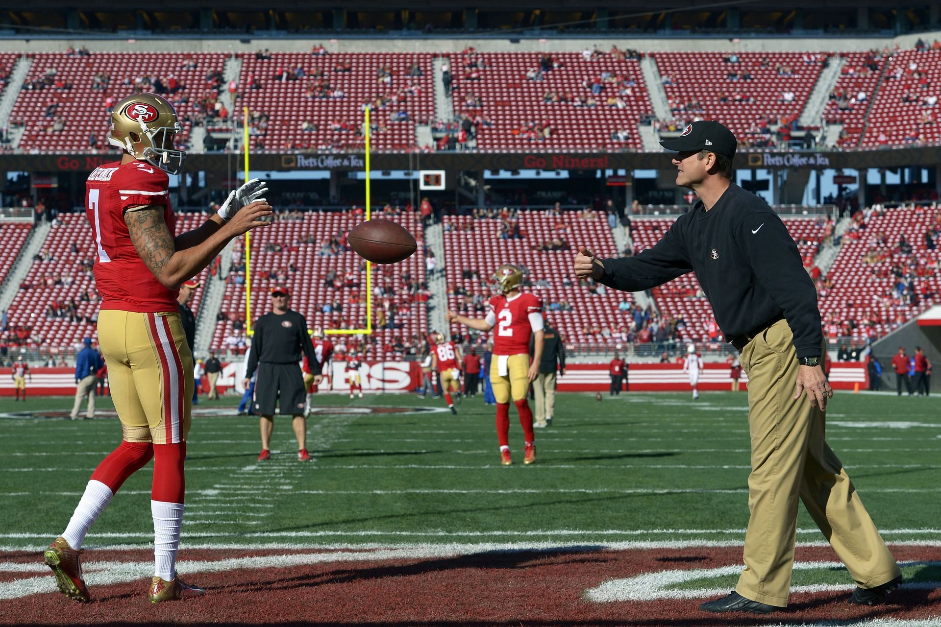 San Francisco 49ers starting quarterback Colin Kaepernick (7) gets a ball from head coach Jim Harbaugh before their NFL game against the Arizona Cardinals at Levi