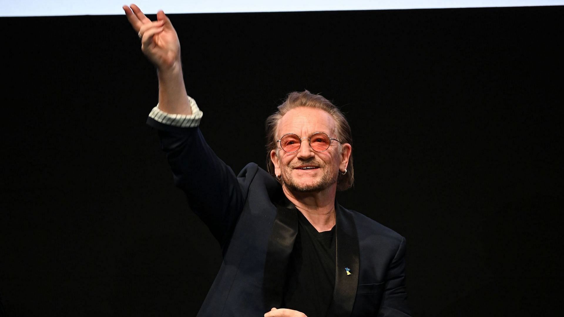 U2 musician Bono performs on stage during the stage presentation of the film &quot;Kiss the Future&quot; at Verti Music Hall. (Image via Getty/Jens Kalaene)