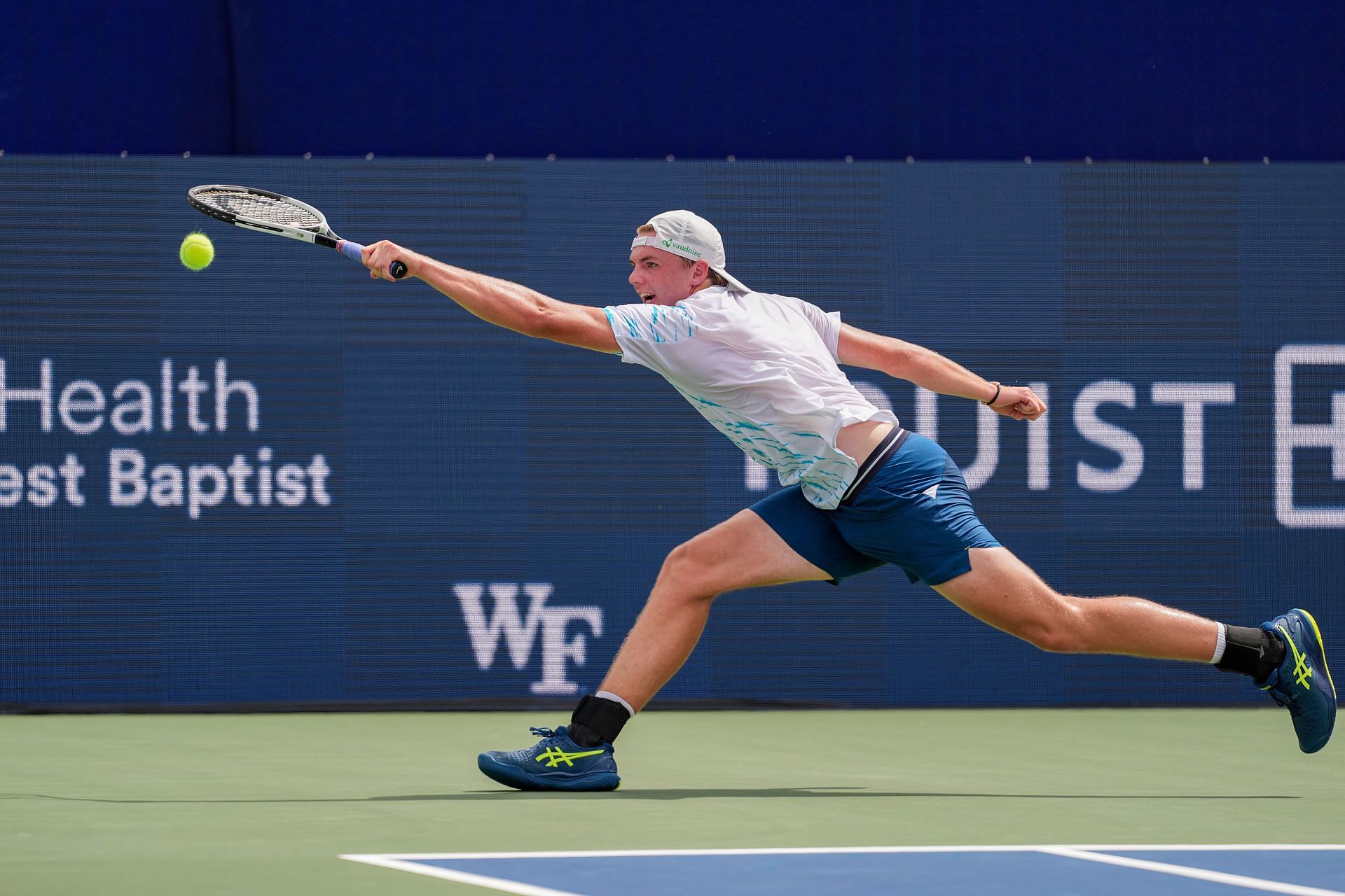 Dominic Stricker streches to play a backhand in the Winston-Salem Open - Source: Getty