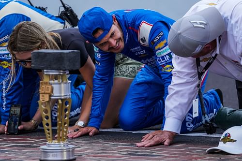 NASCAR Cup Series driver Kyle Larson (5) looks over at owner of Hendrick Motorsports Rick Hendrick during the kissing of the bricks following the Brickyard 400, Sunday, July 21, 2024, at Indianapolis Motor Speedway. Source: Imagn