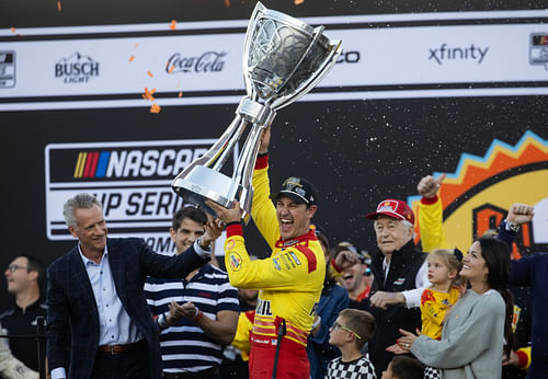 NASCAR Cup Series driver Joey Logano (right) is presented the Bill France Trophy by NASCAR president Steve Phelps after winning the 2024 NASCAR Cup Series championship. Source: Imagn Images