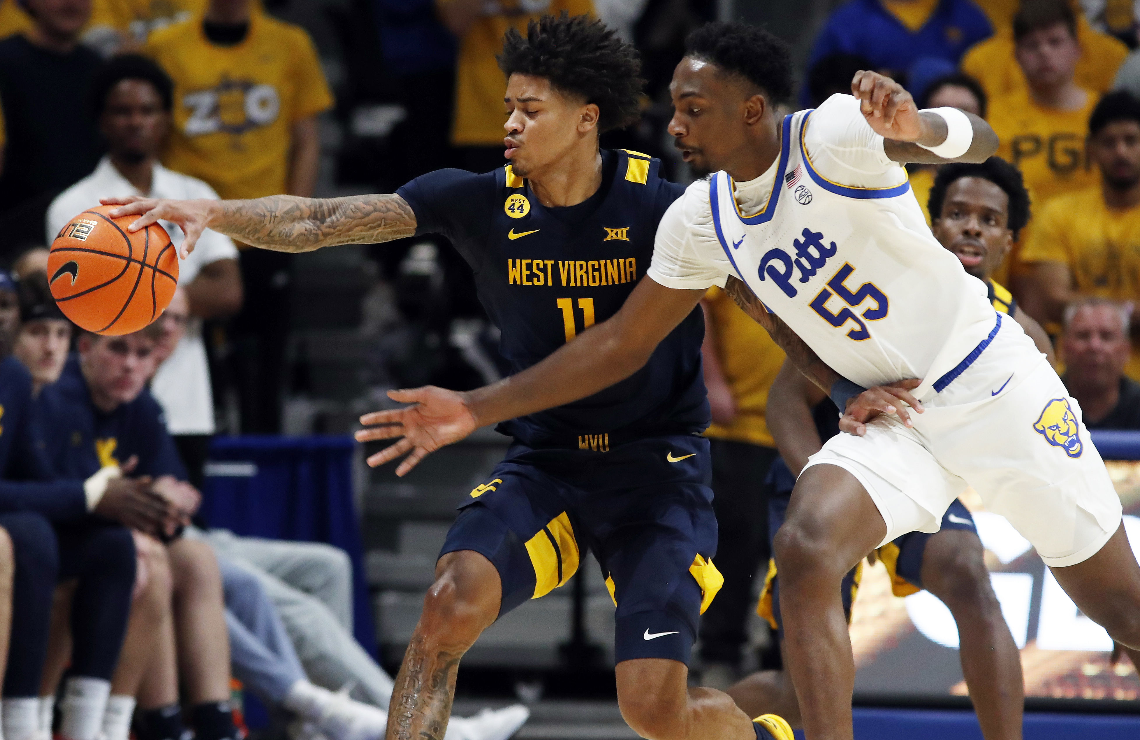 West Virginia Mountaineers guard Jonathan Powell (11) and Pittsburgh Panthers forward Zack Austin (55) fight for a loose ball during the second half at the Petersen Events Center. Photo: Imagn