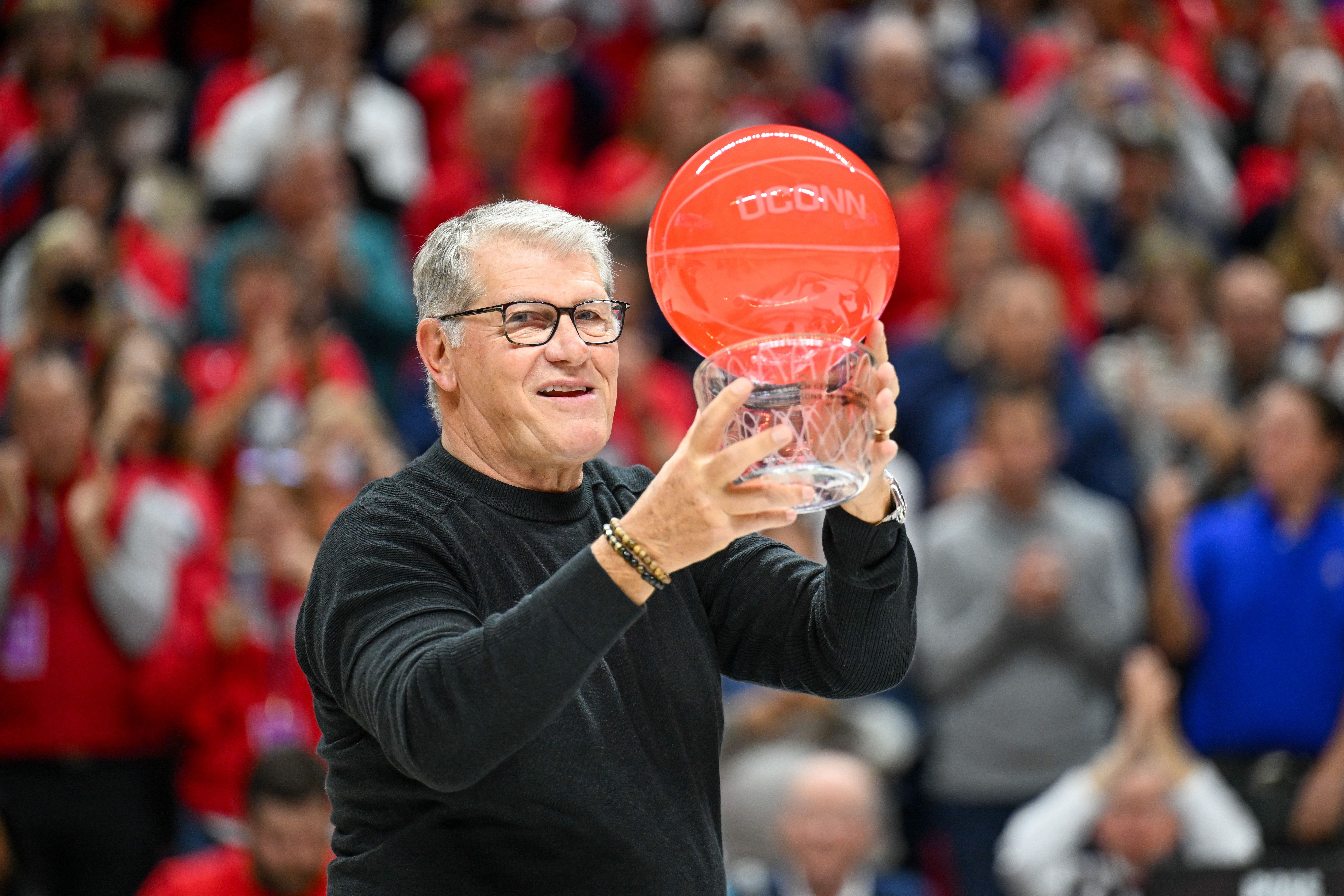 Geno Auriemma raises his glass-blown basketball. (Image Credits: Imagn)