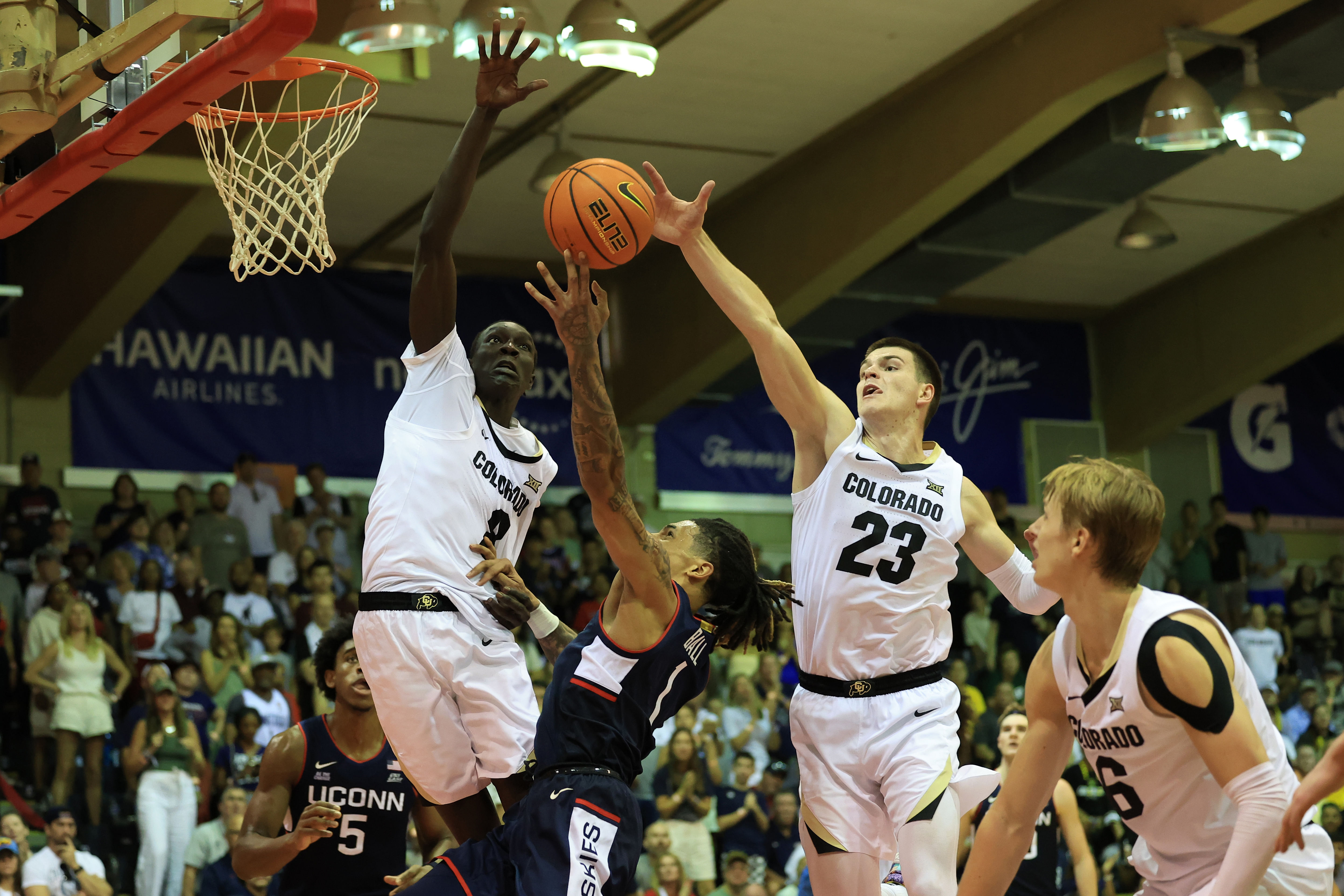 Connecticut Huskies guard Solo Ball (1) attempts a layup in between Colorado Buffaloes forward Bangot Dak (8) and forward Andrej Jakimovski (23) during the second half of their NCAA game. Photo: Imagn