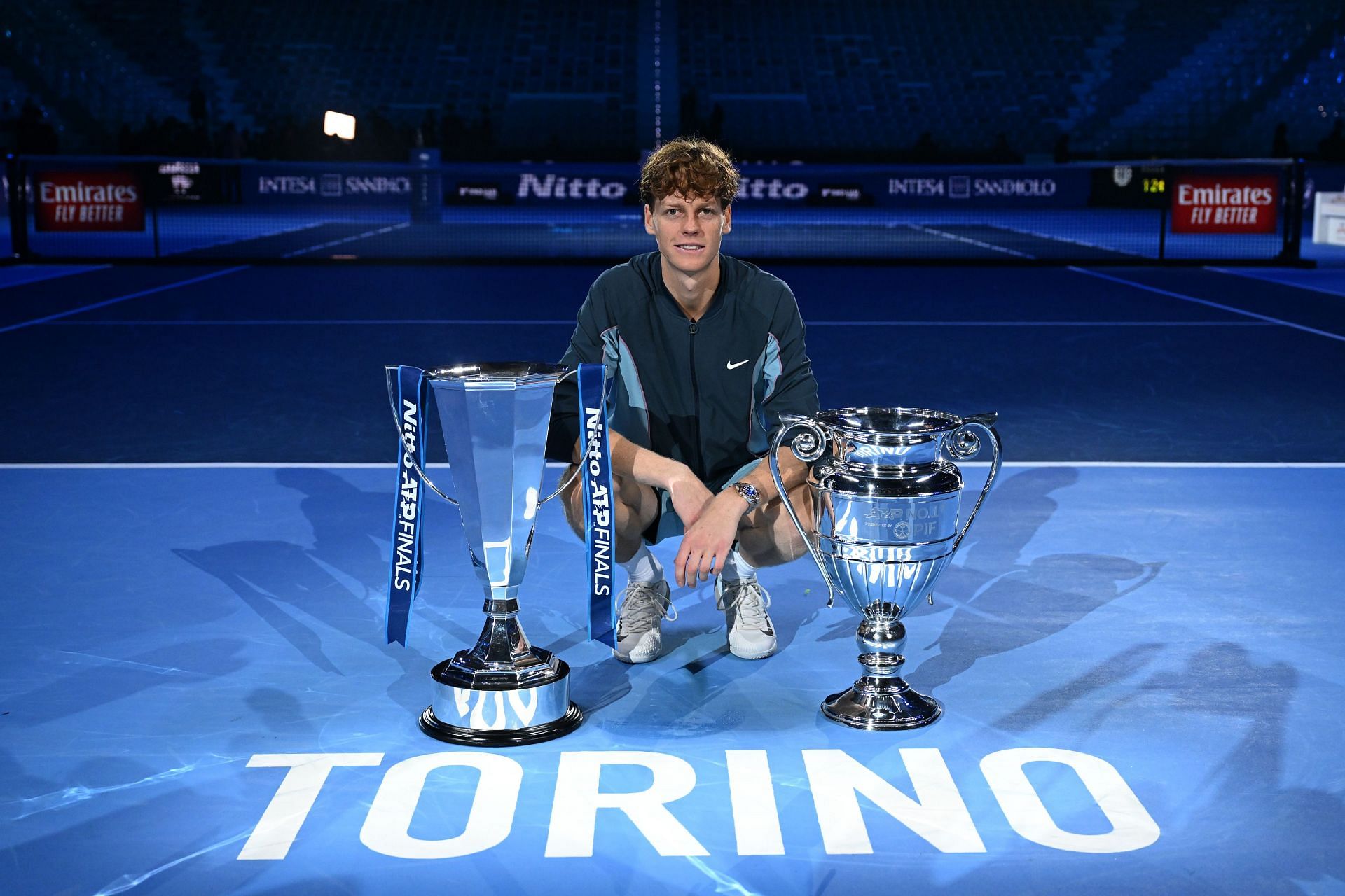 Jannik Sinner poses with the year-end No. 1 and the ATP Finals trophy