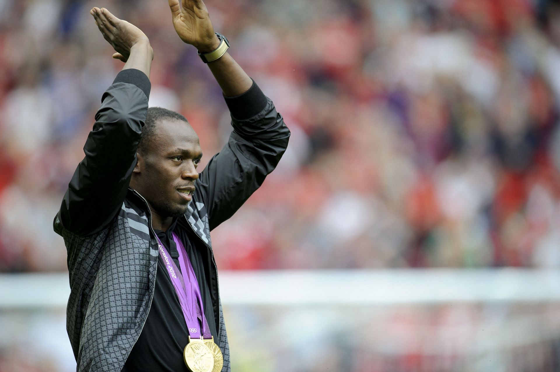 Bolt with his gold medal during a Manchester United v Fulham Premier League game (Image via: Getty Images)