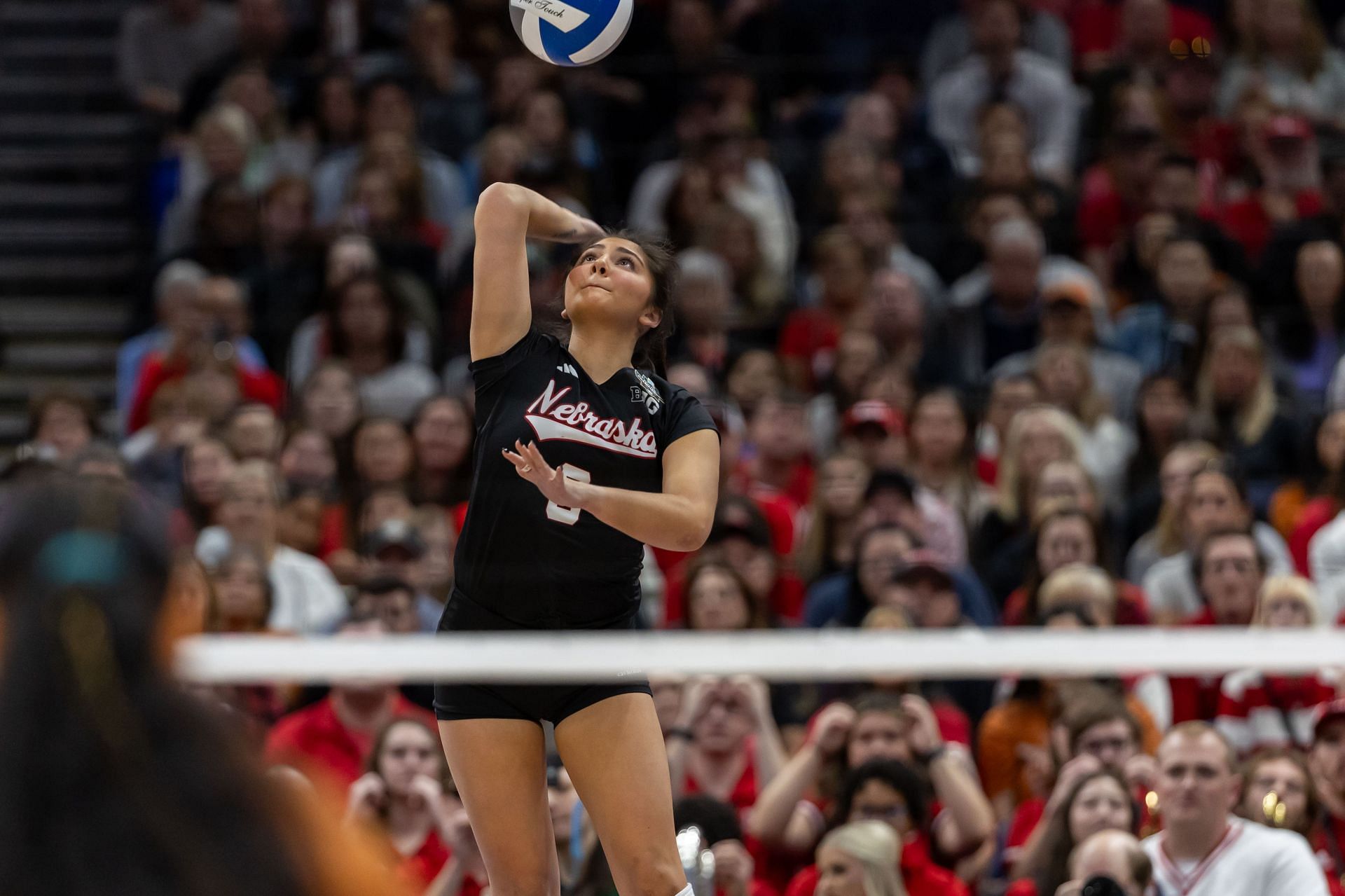 Lexi Rodriguez doing a serve during a NCAA Championships match against Texas Longhorns (Image via: Getty Images)