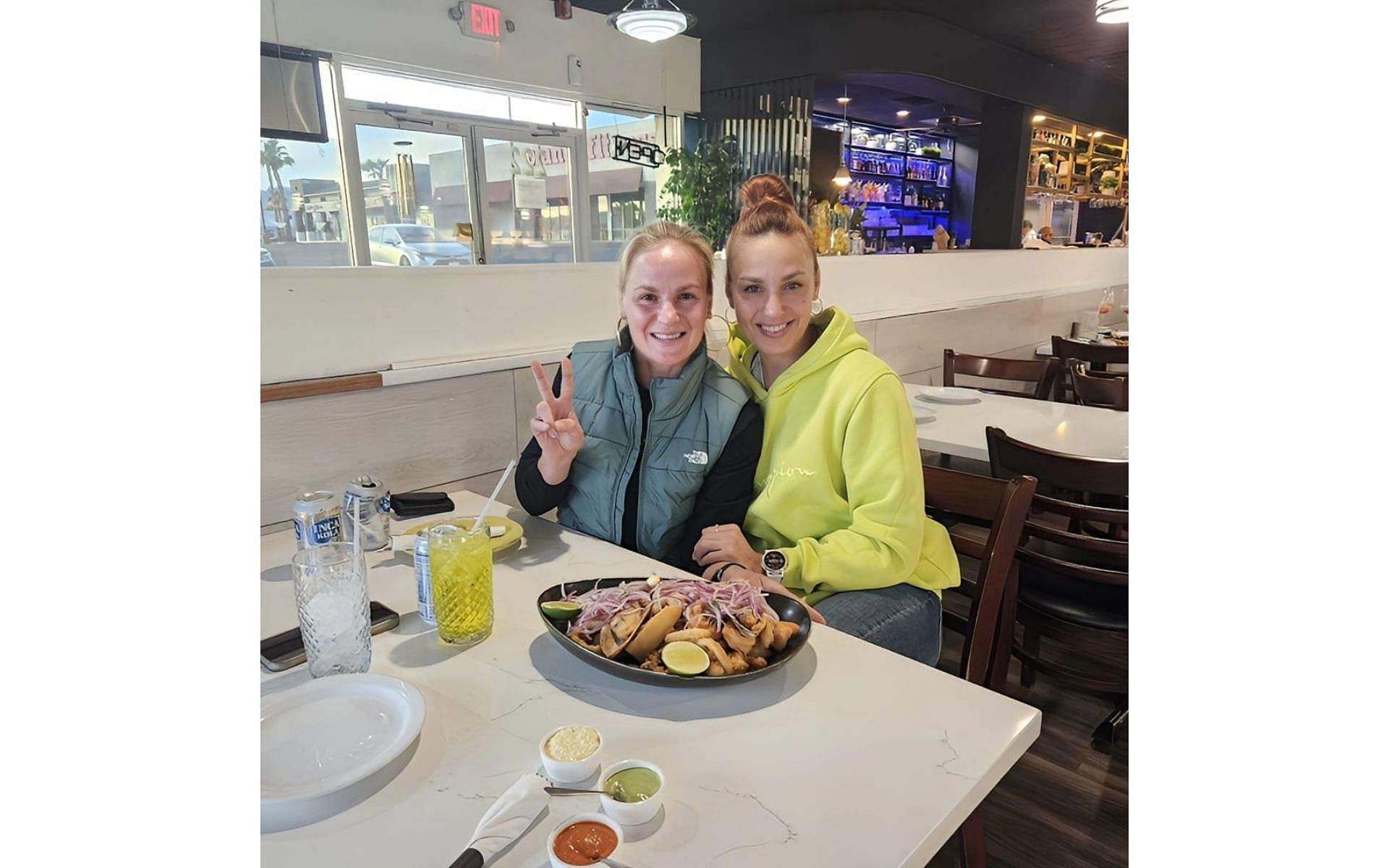 The sisters pose with food and drinks in the foreground [Image courtesy: @bulletvalentina on Instagram]