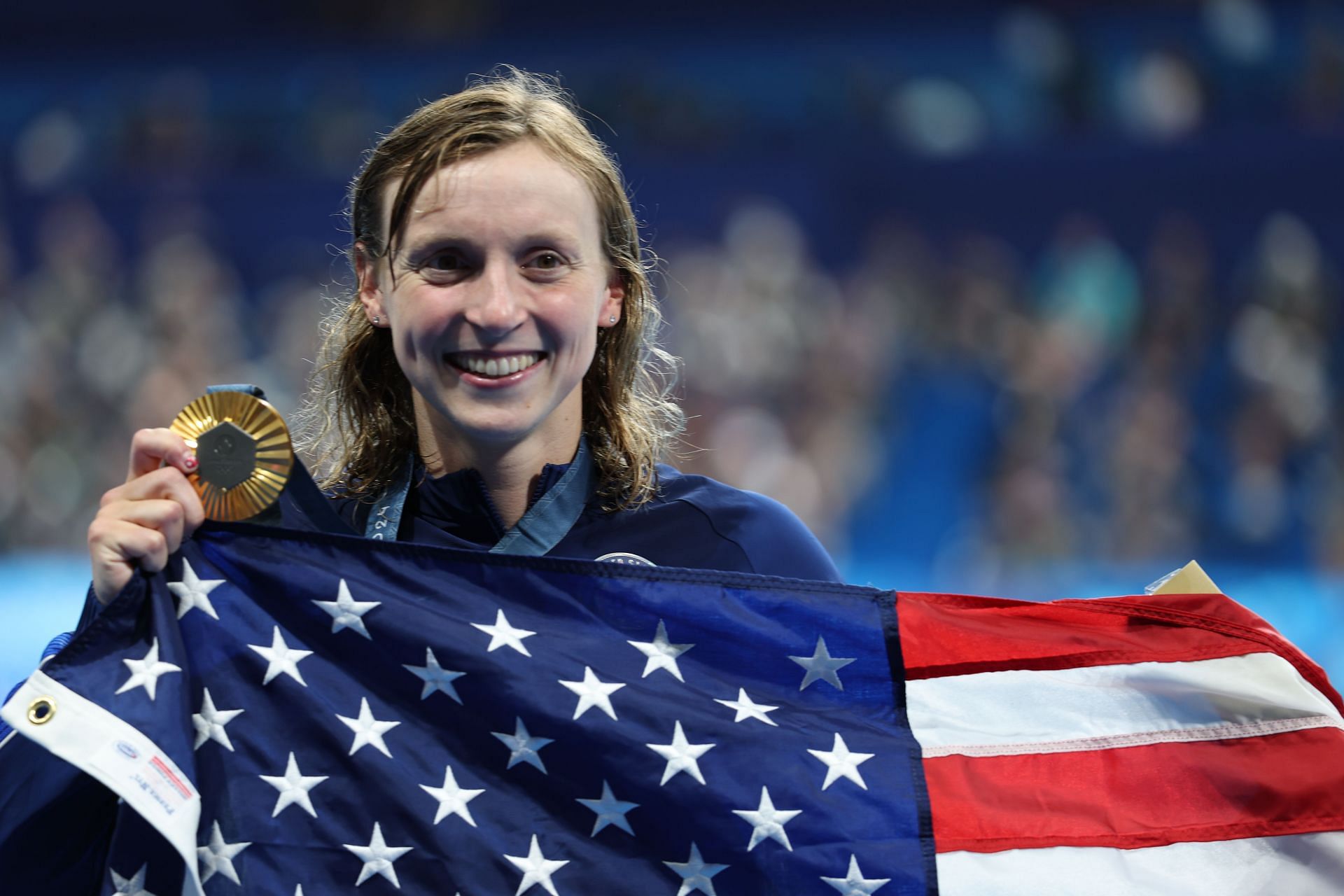 Katie Ledecky celebrates with the US flag after winning the Women&#039;s 1500m freestyle event at the 2024 Paris Olympics (Image via Getty Images)