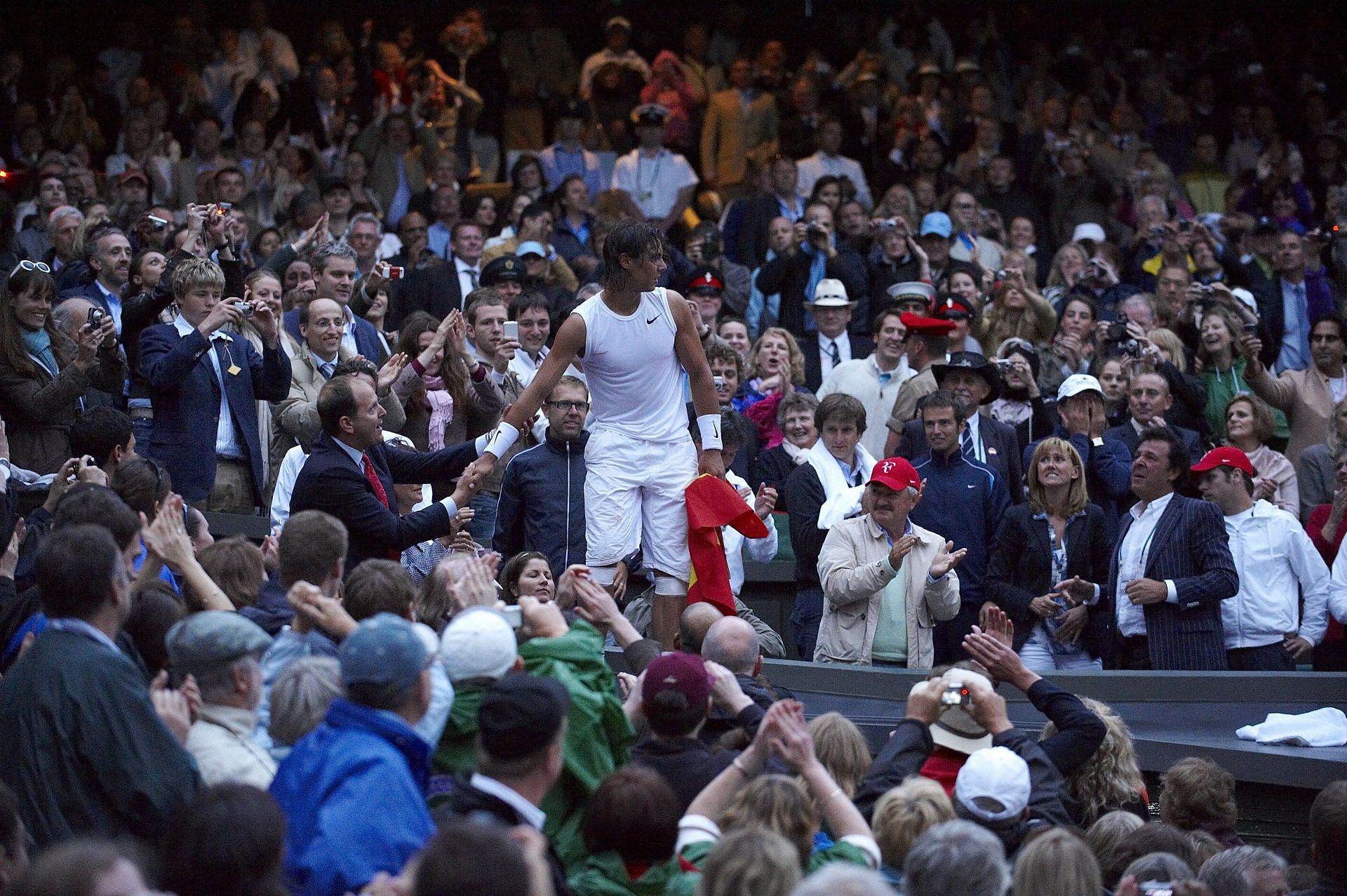 Nadal carrying the Spanish flag after conquering Roger Federer to win 2008 Wimbledon - Source: Getty