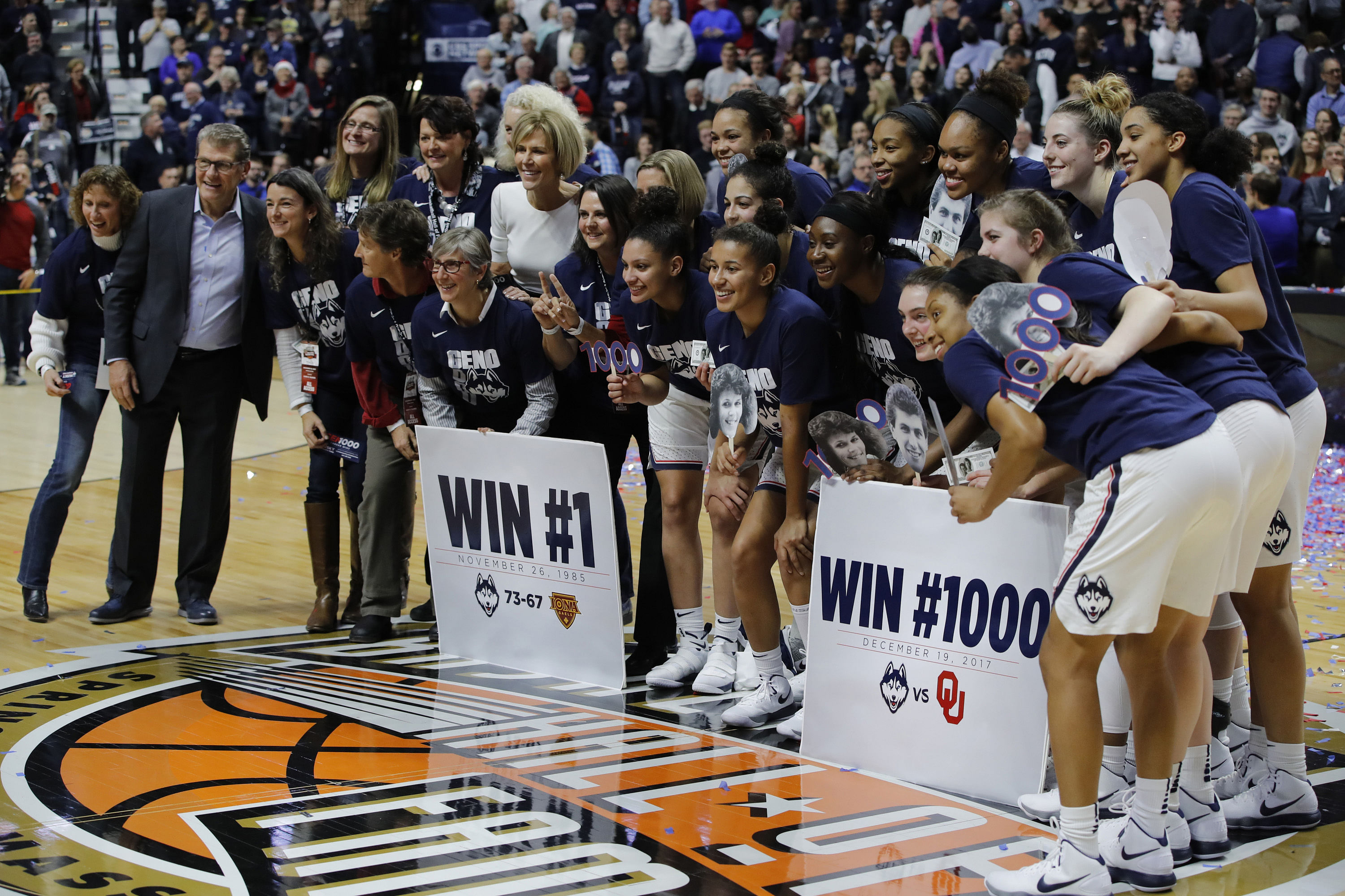 Connecticut Huskies head coach Geno Auriemma (far left) celebrates his 1000th win with his assistant coaches and players after defeating the Oklahoma Sooners at Mohegan Sun Arena. Photo: Imagn