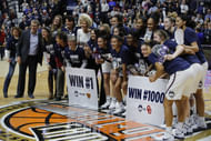Connecticut Huskies head coach Geno Auriemma (far left) celebrates his 1000th win with his assistant coaches and players after defeating the Oklahoma Sooners at Mohegan Sun Arena. Photo: Imagn