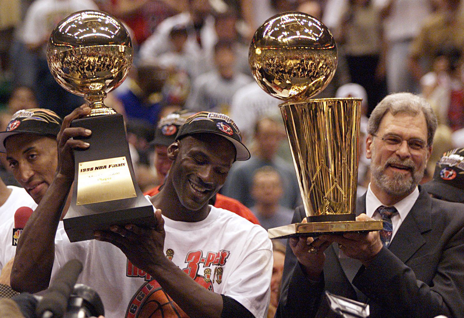 Michael Jordan holds the MVP trophy and coach Phil Jackson holds the championship trophy after the Chicago Bulls beat the Utah Jazz to win their sixth NBA title. Photo: Imagn