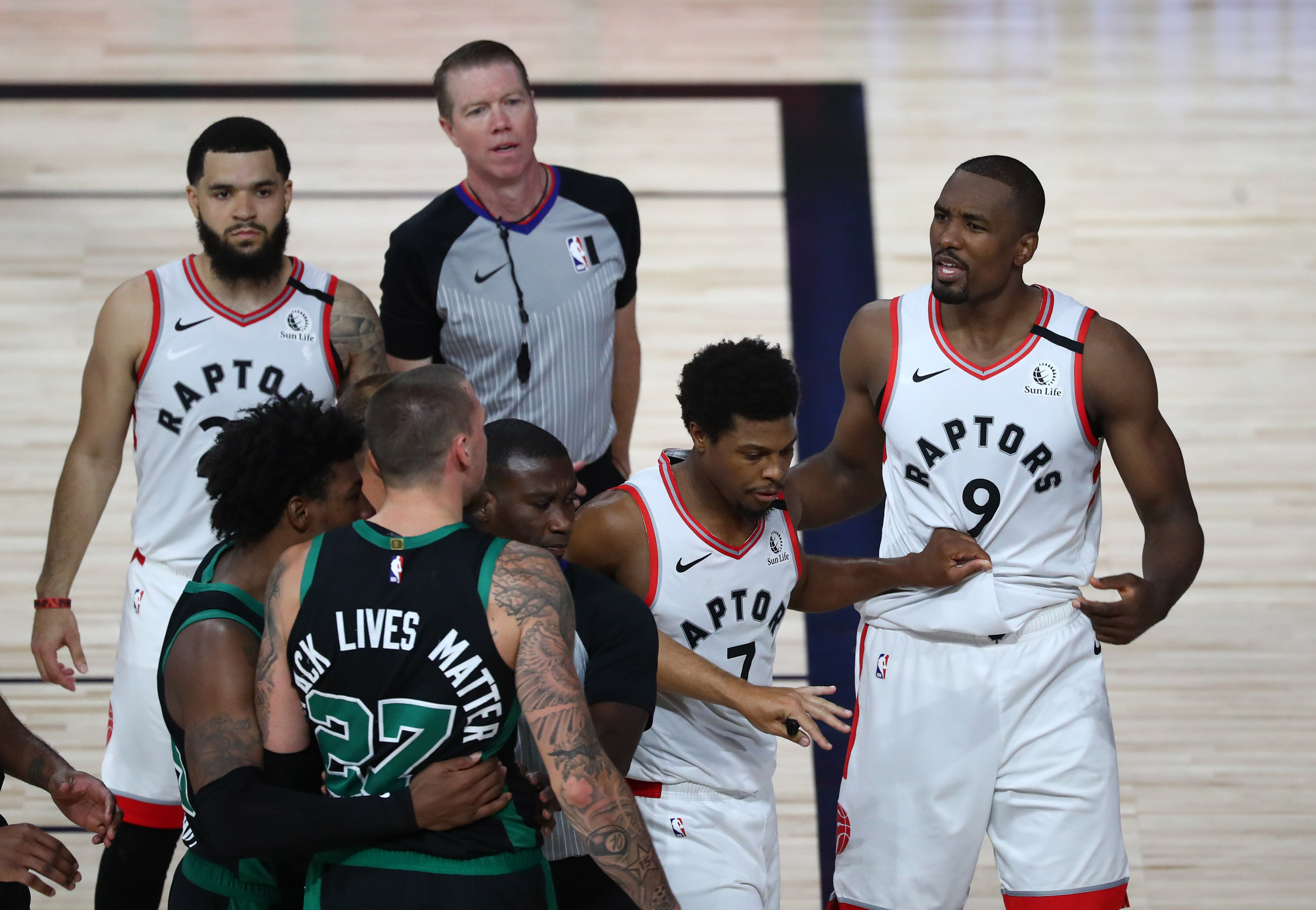 Toronto Raptors center Serge Ibaka (9) is held back by guard Kyle Lowry (7) and an official after being called for a flagrant foul against Boston Celtics center Daniel Theis (27) - Source: Imagn