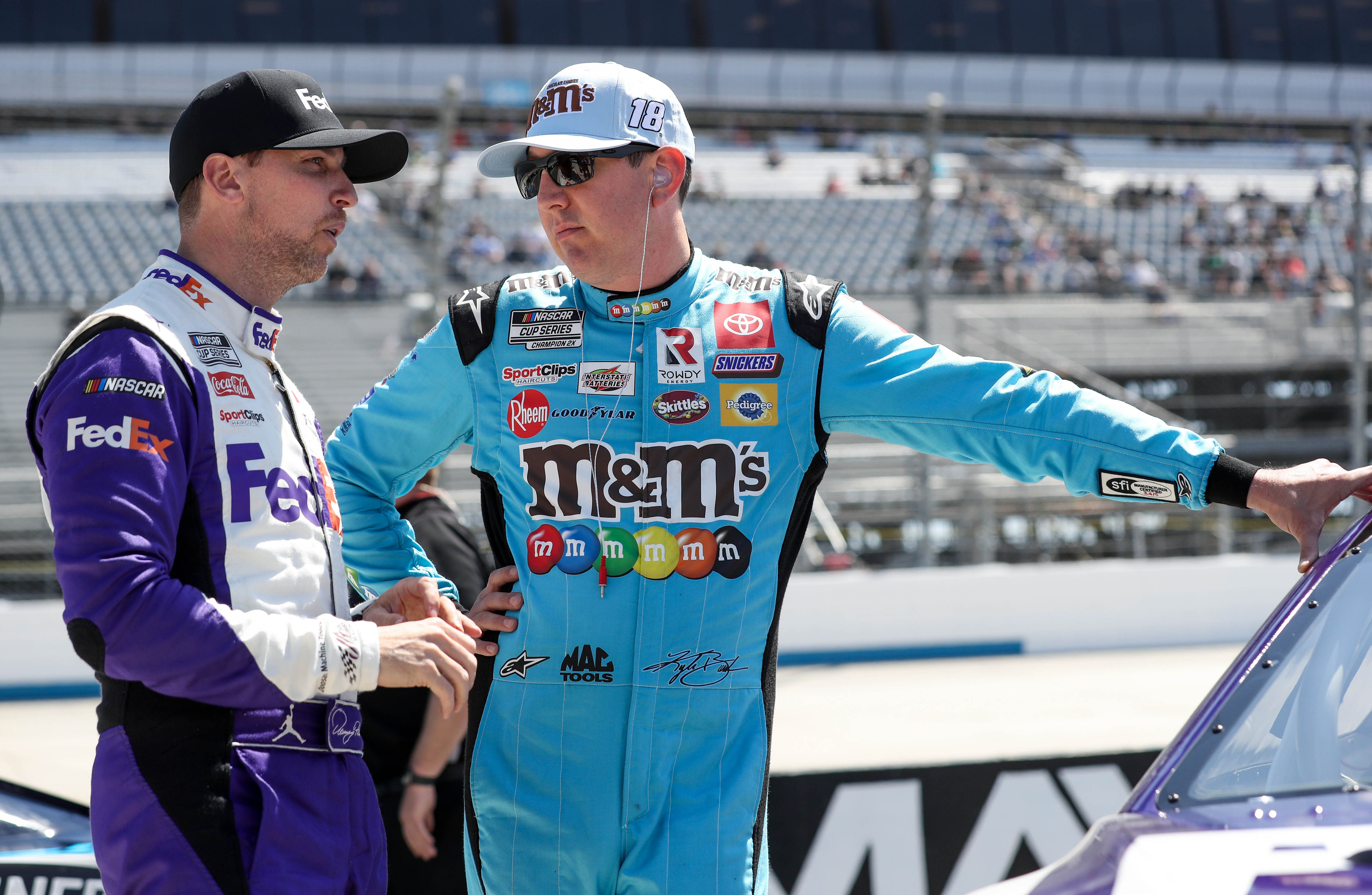 Kyle Busch (right) talks with Denny Hamlin (left) on pit road during qualifying for the DuraMAX Drydene 400 - Source: Imagn