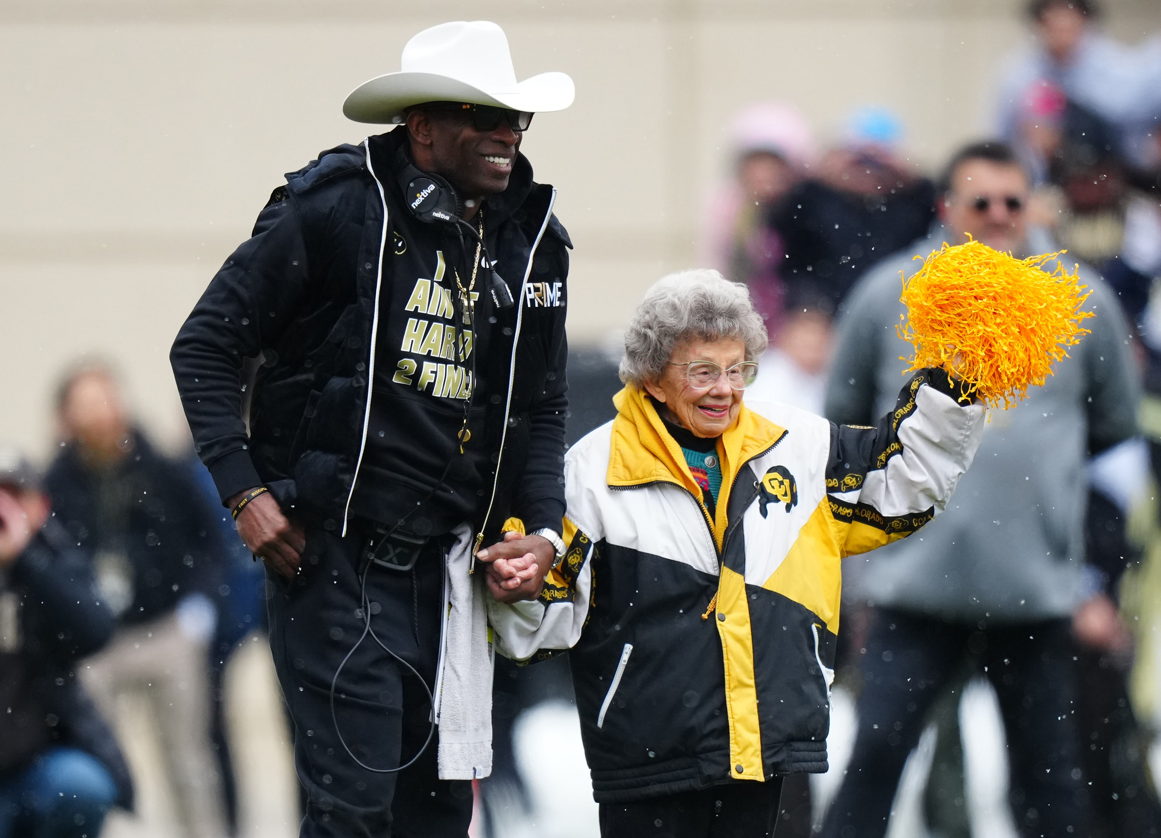 Colorado Buffaloes head coach holds the hand of fan Peggy Coppom - Source: Imagn