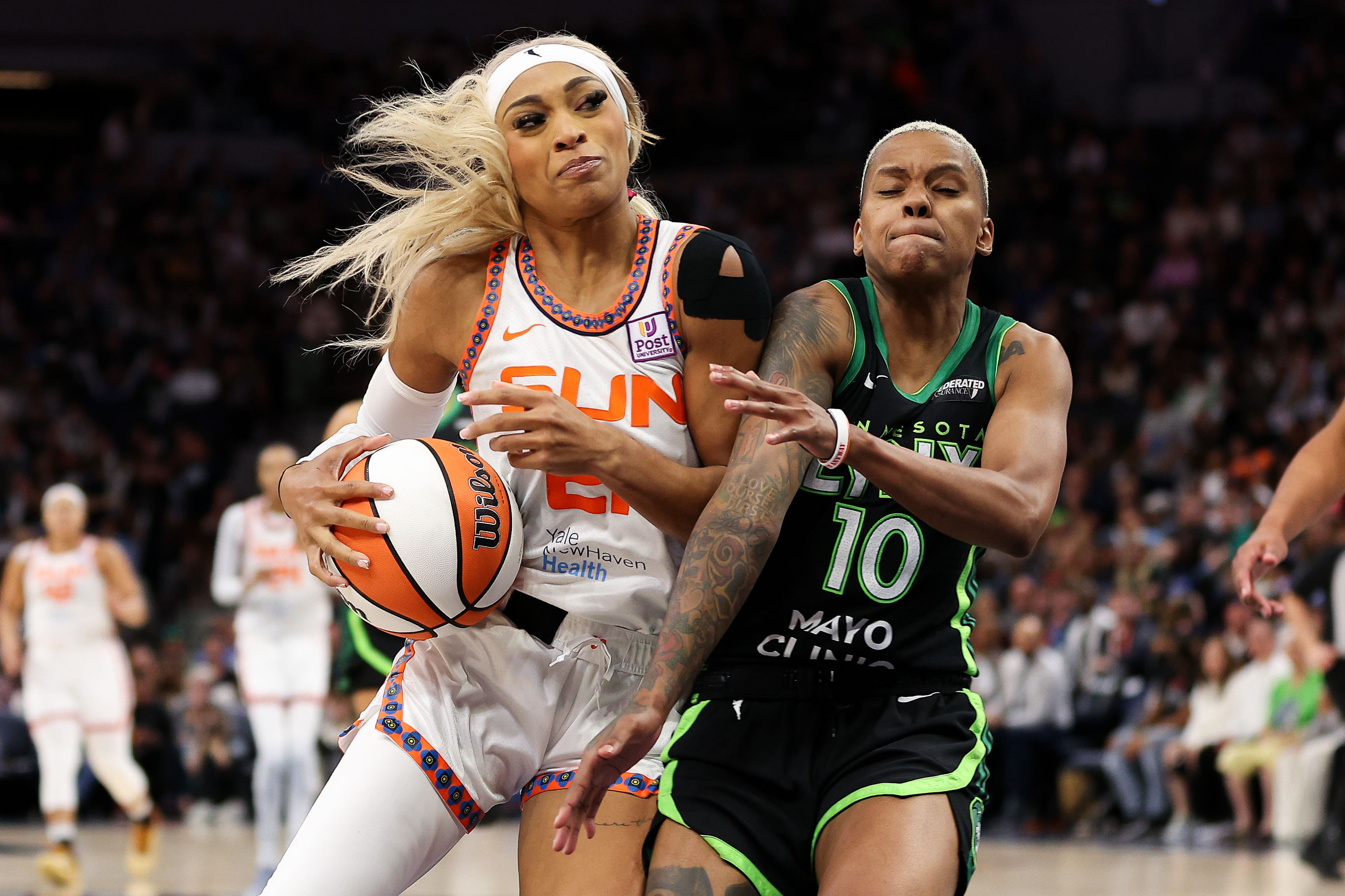 Oct 8, 2024; Minneapolis, Minnesota, USA; Connecticut Sun guard DiJonai Carrington (21) works towards the basket as Minnesota Lynx guard Courtney Williams (10) defends during the second half of game five of the 2024 WNBA playoffs at Target Center. Mandatory Credit: Matt Krohn-Imagn Images - Source: Imagn