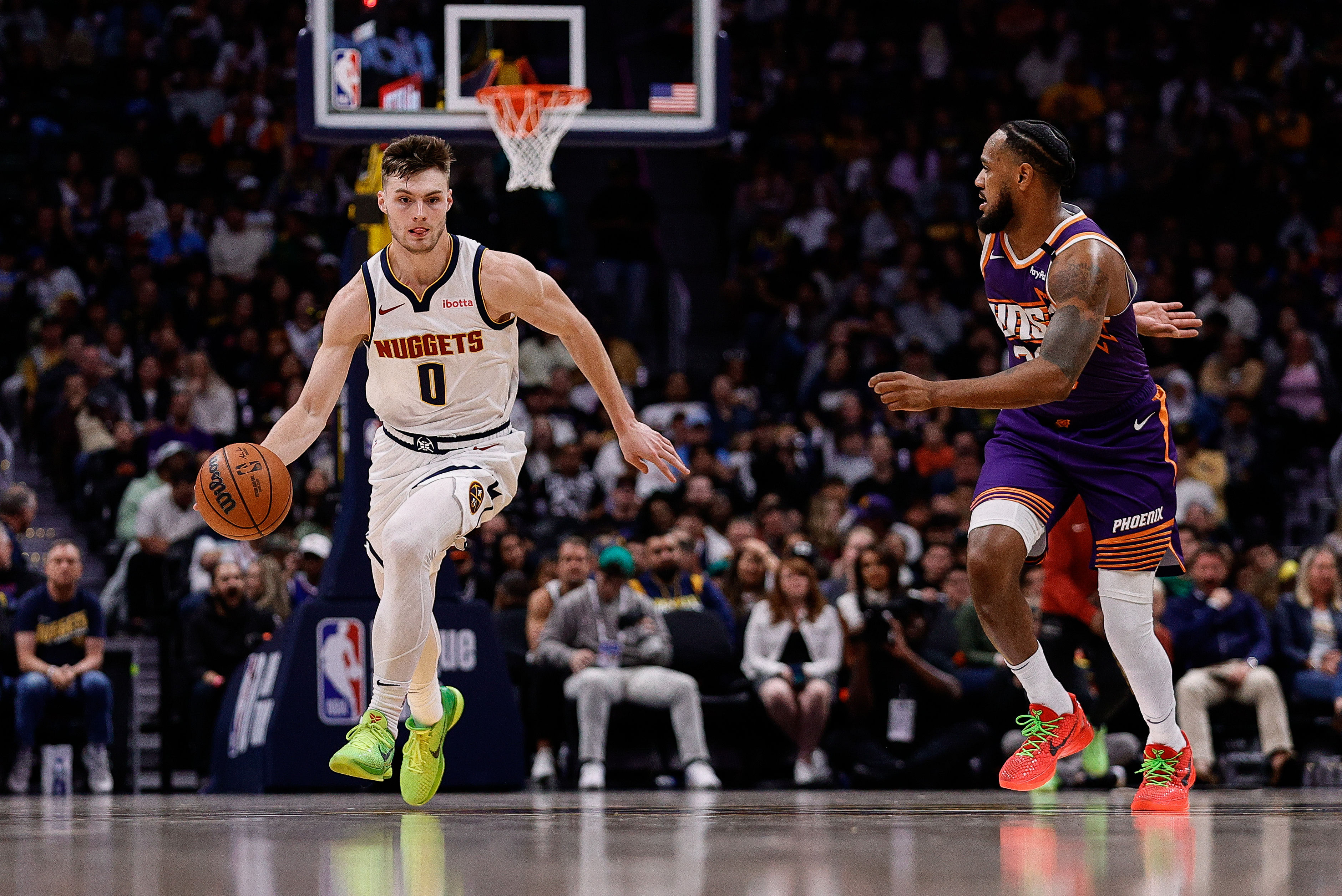 Denver Nuggets guard Christian Braun dribbles the ball up court against Phoenix Suns guard Monte Morris at Ball Arena. Photo Credit: Imagn