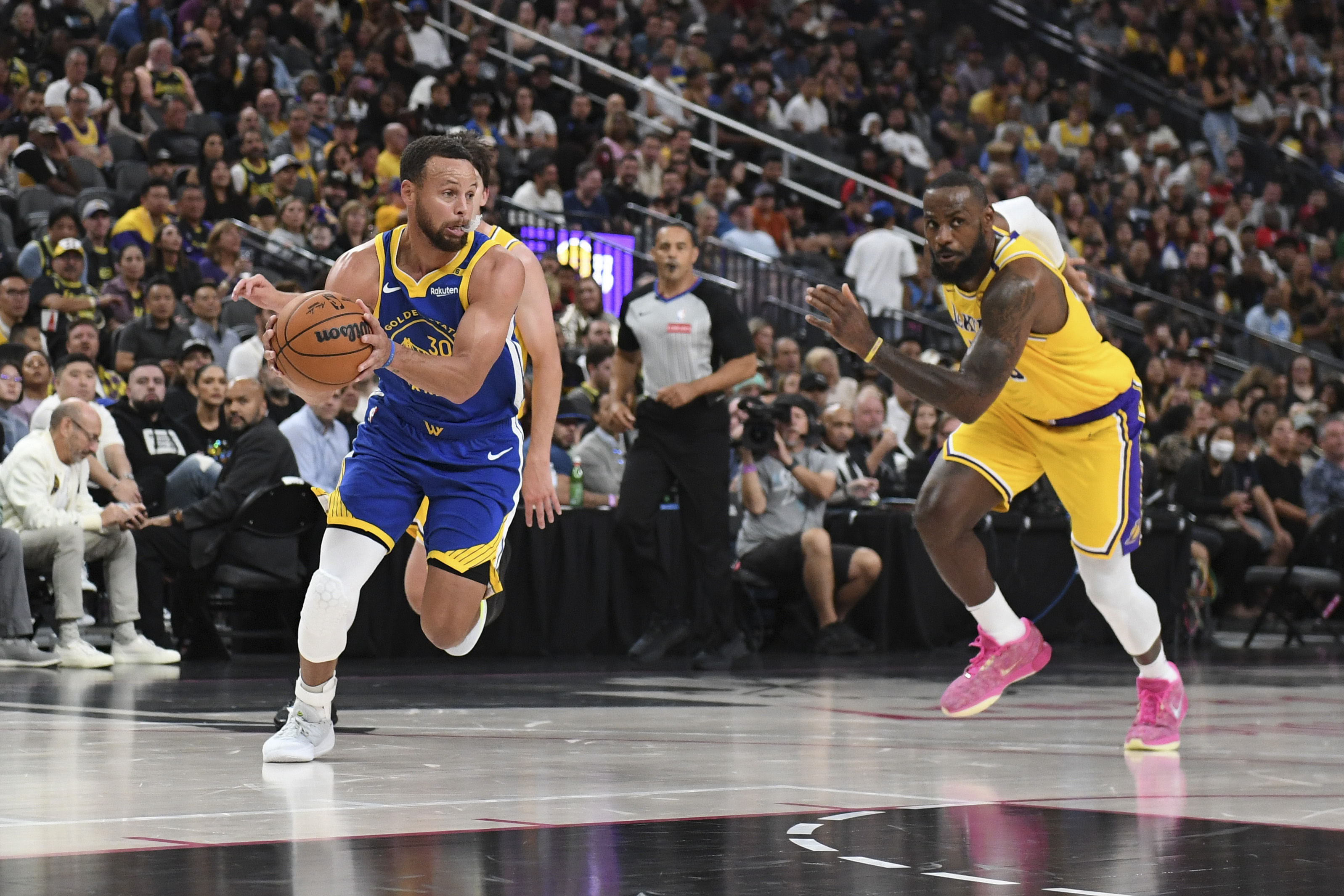 Golden State Warriors guard Stephen Curry (30) drives past Los Angeles Lakers forward LeBron James (23) during their preseason matchup. (Credits: IMAGN)