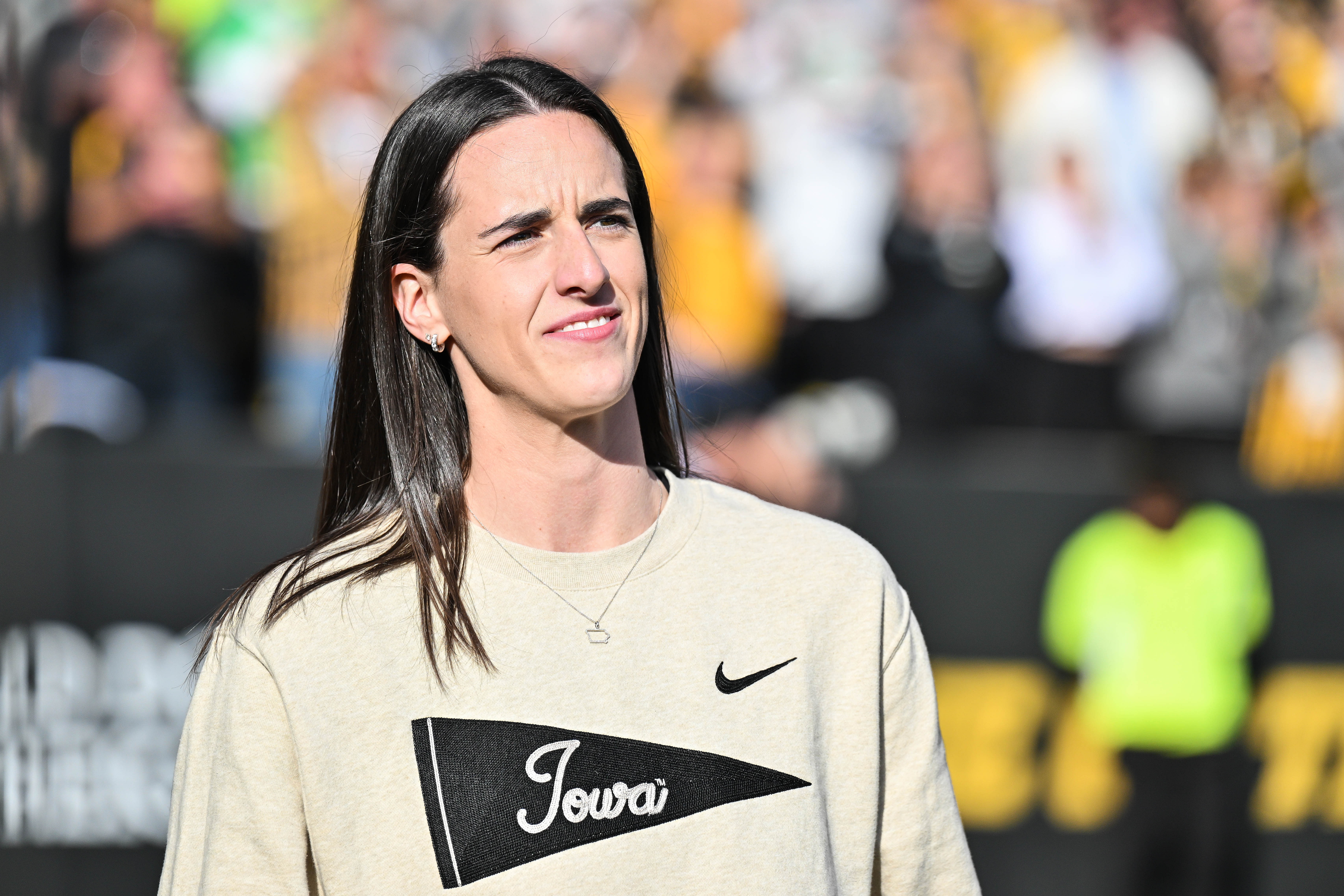 Former Iowa Hawkeye and current Indiana Fever WNBA star Caitlin Clark looks on while being honored during a game at Kinnick Stadium. Photo Credit: Imagn