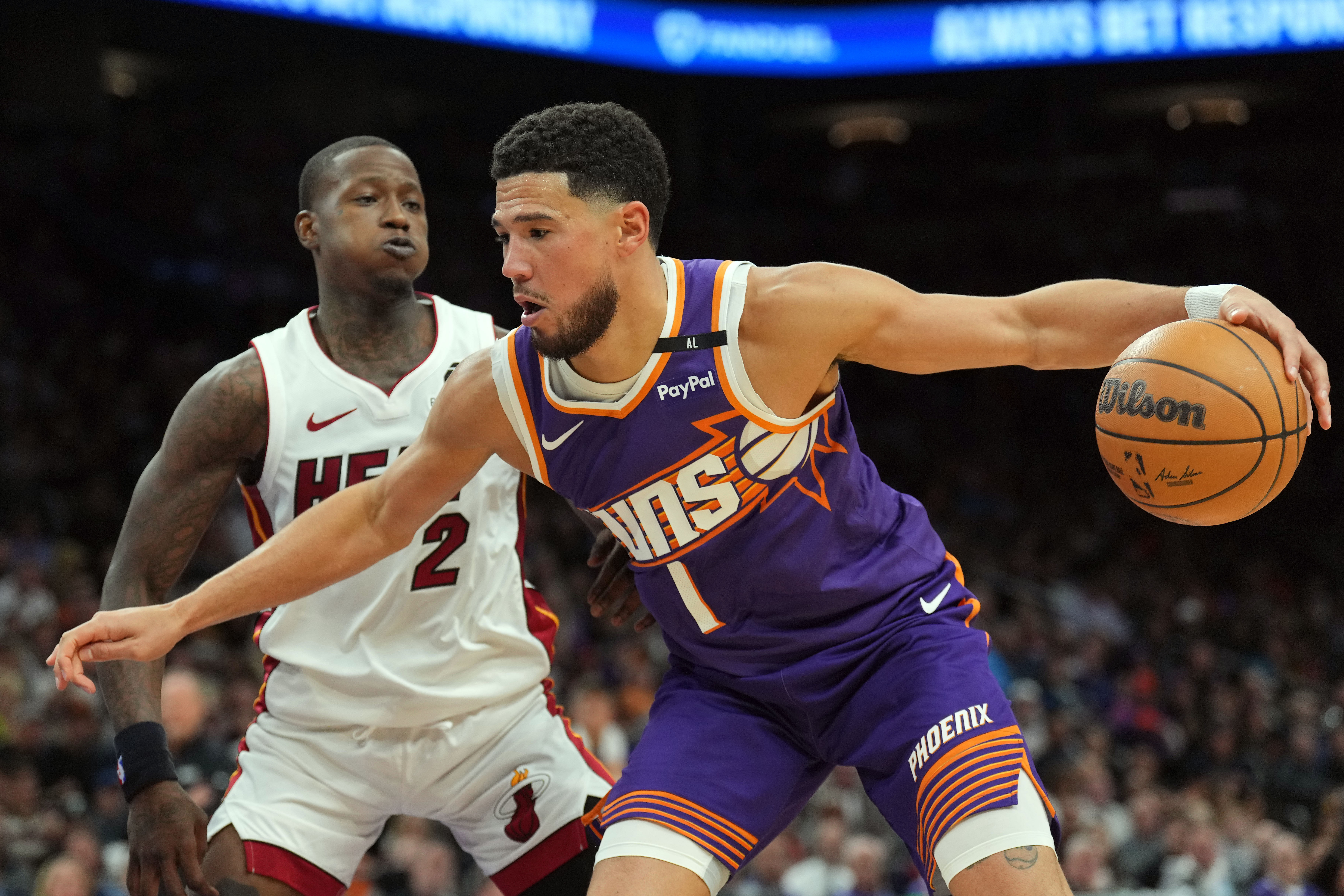 Phoenix Suns guard Devin Booker dribbles against Miami Heat guard Terry Rozier during the first half at Footprint Center (Credits: IMAGN)