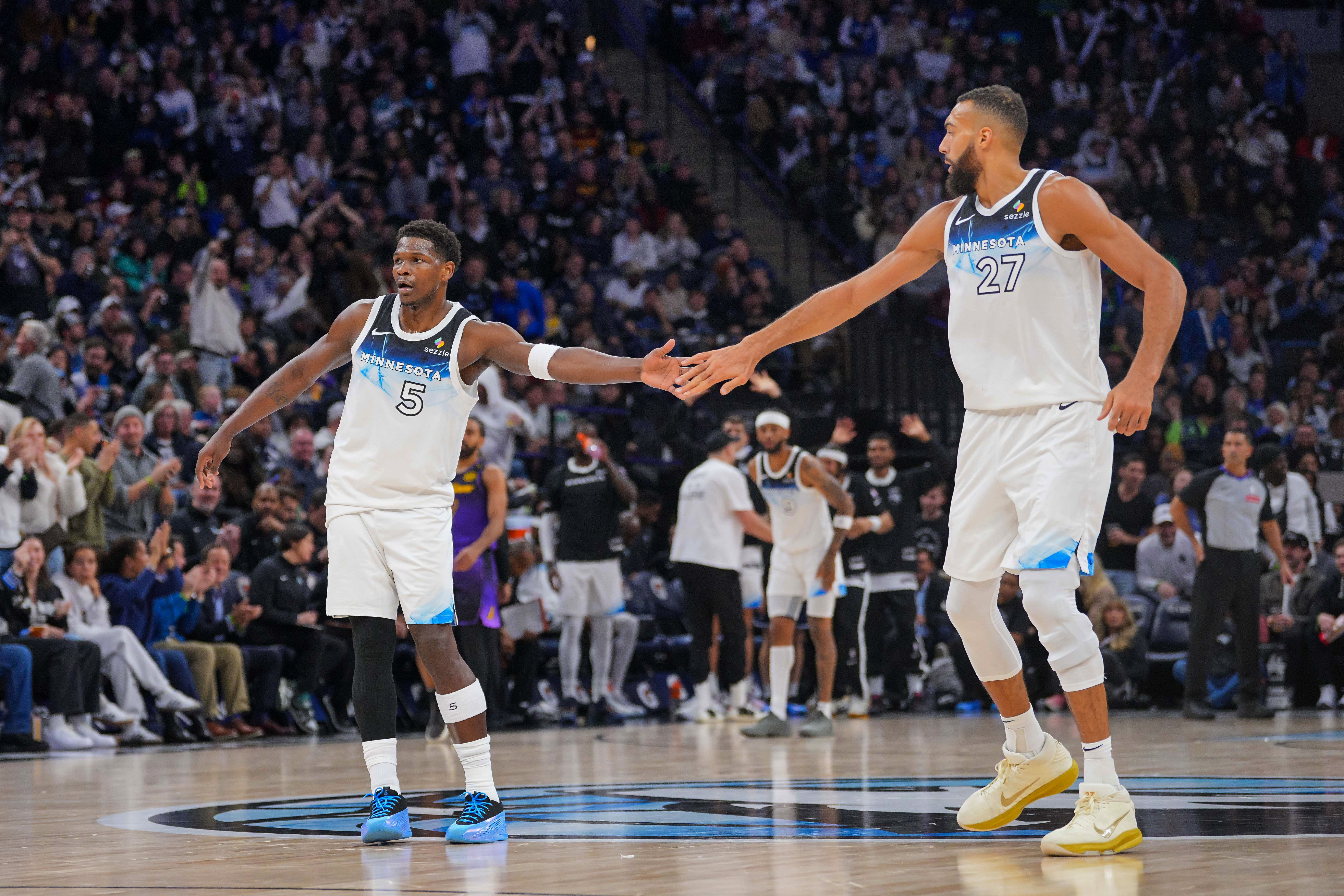 Dec 2, 2024; Minneapolis, Minnesota, USA; Minnesota Timberwolves guard Anthony Edwards (5) high fives center Rudy Gobert (27) against the Los Angeles Lakers in the third quarter at Target Center. Mandatory Credit: Brad Rempel-Imagn Images - Source: Imagn