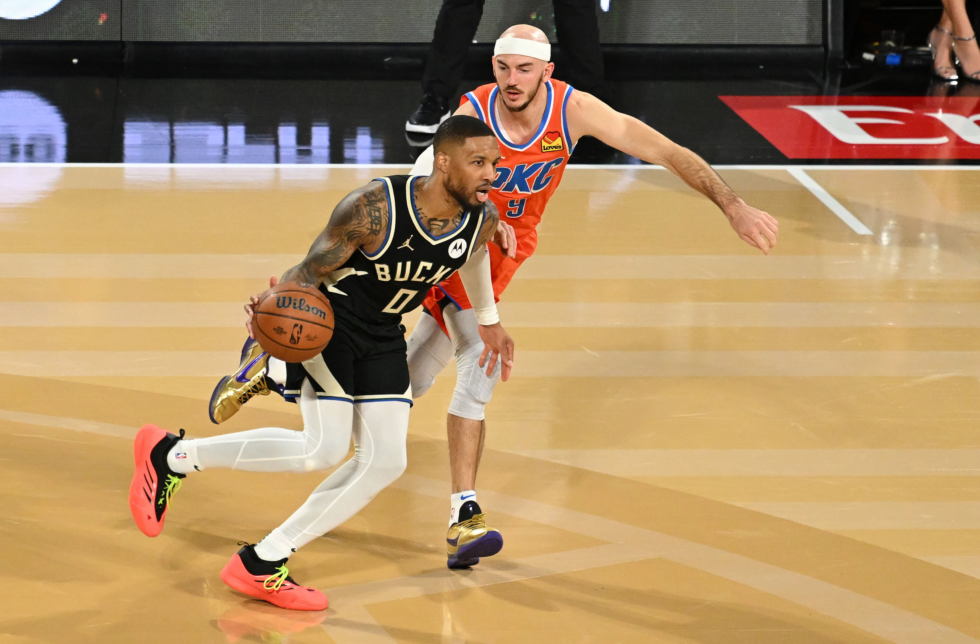 Dec 17, 2024; Las Vegas, Nevada, USA; Milwaukee Bucks guard Damian Lillard (0) dribbles against Oklahoma City Thunder guard Alex Caruso (9) during the 4th quarter in the Emirates NBA Cup championship game at T-Mobile Arena. Mandatory Credit: Candice Ward-Imagn Images - Source: Imagn