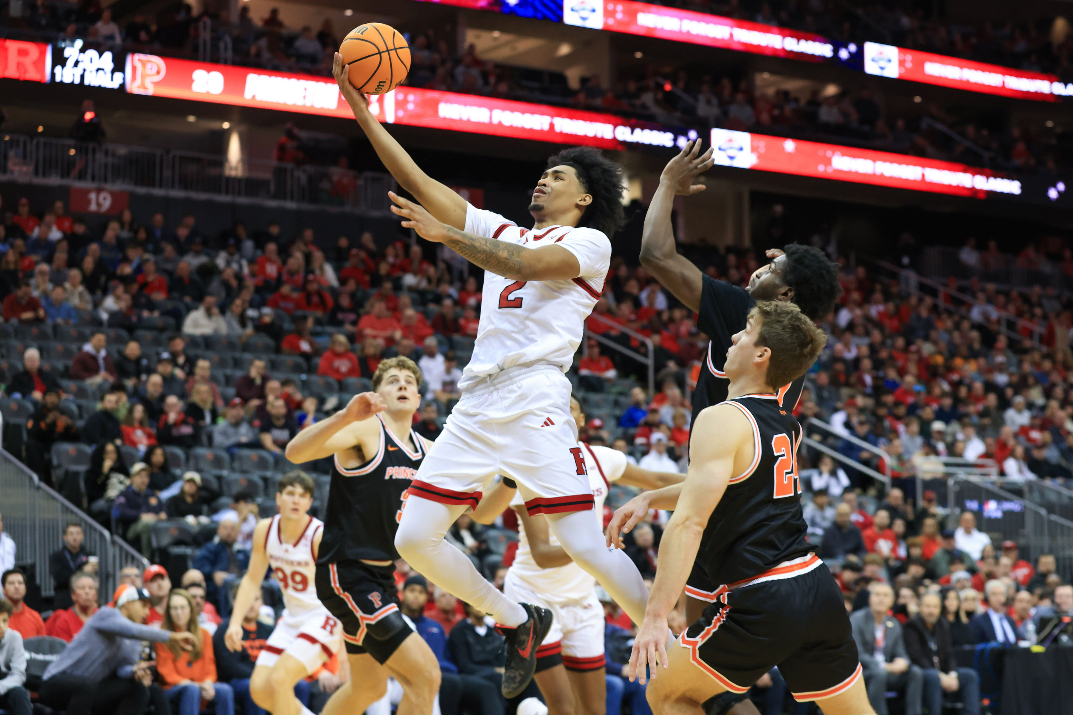 Rutgers Scarlet Knights guard Dylan Harper (#2) shoots the ball while being defended by Princeton Tigers guards Dalen Davis (#22) and Blake Peters (#24) during the first half at Prudential Center. Photo: Imagn