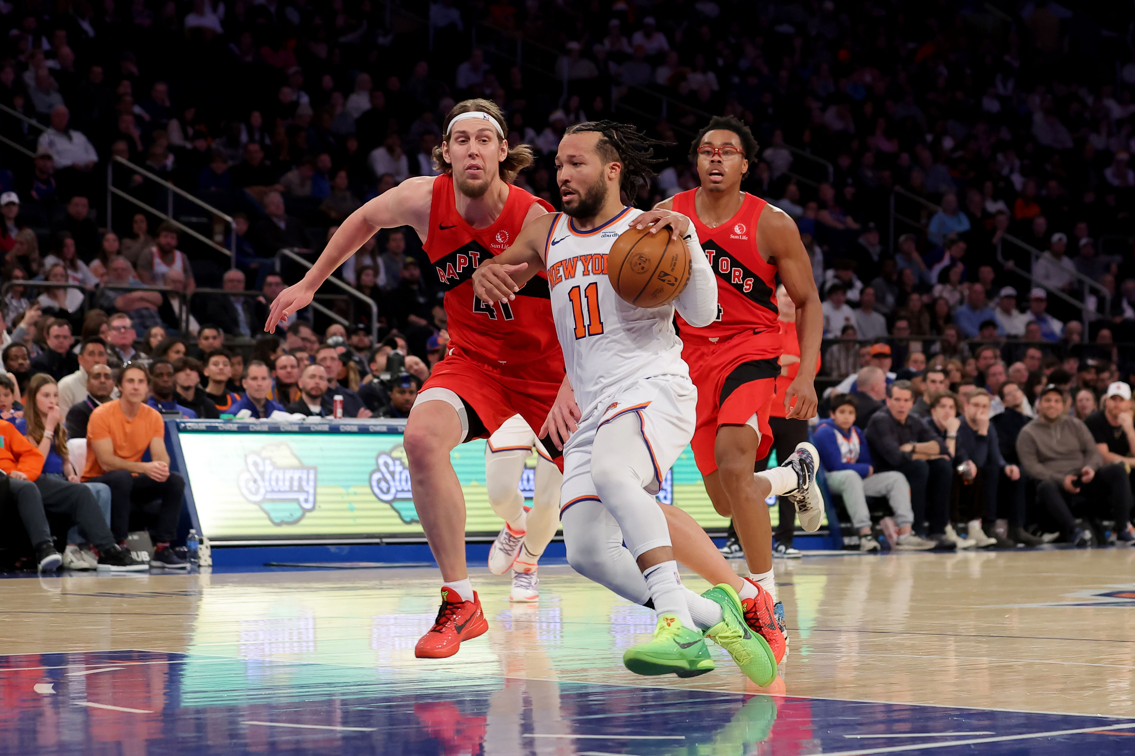 New York Knicks guard Jalen Brunson (11) drives to the basket against Toronto Raptors forwards Kelly Olynyk (41) and Scottie Barnes (4) - Source: Imagn