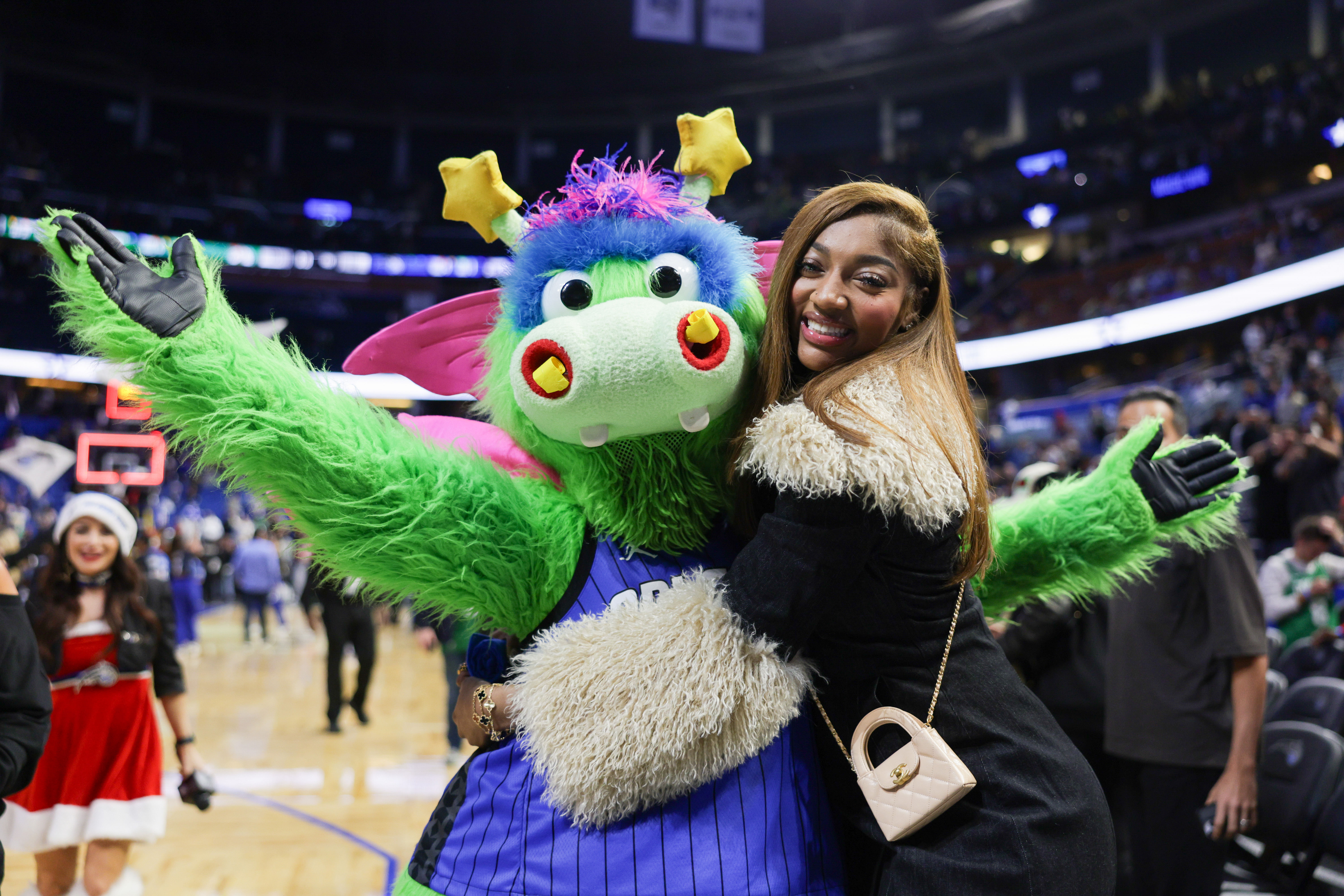 Dec 23, 2024; Orlando, Florida, USA; Chicago Sky forward Angel Reese hugs Orlando Magic Stuff during an NBA game against the Boston Celtics at Kia Center. Mandatory Credit: Nathan Ray Seebeck-Imagn Images - Source: Imagn