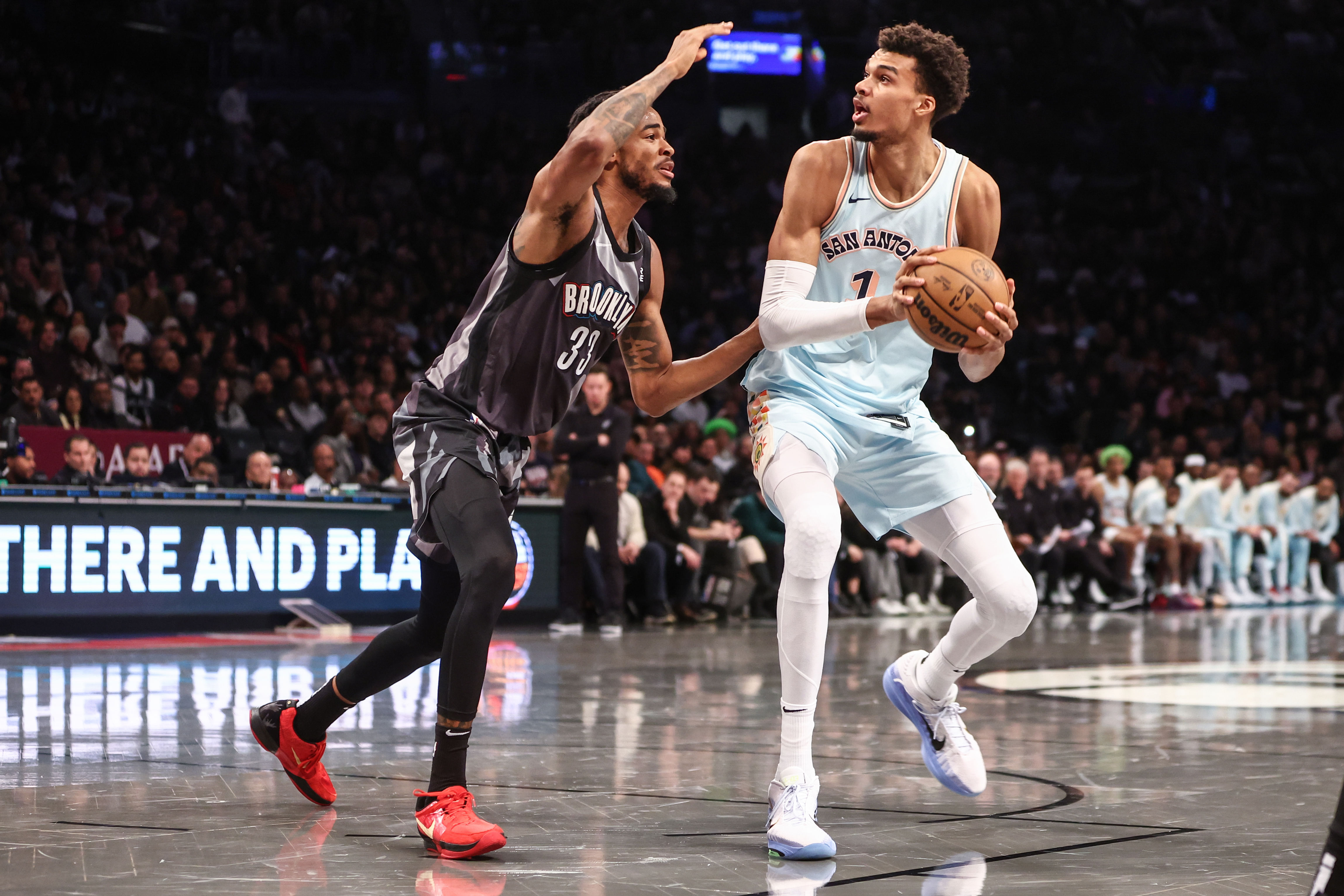 Dec 27, 2024; Brooklyn, New York, USA; San Antonio Spurs center Victor Wembanyama (1) looks to drive past Brooklyn Nets center Nic Claxton (33) in the second quarter at Barclays Center. Mandatory Credit: Wendell Cruz-Imagn Images - Source: Imagn