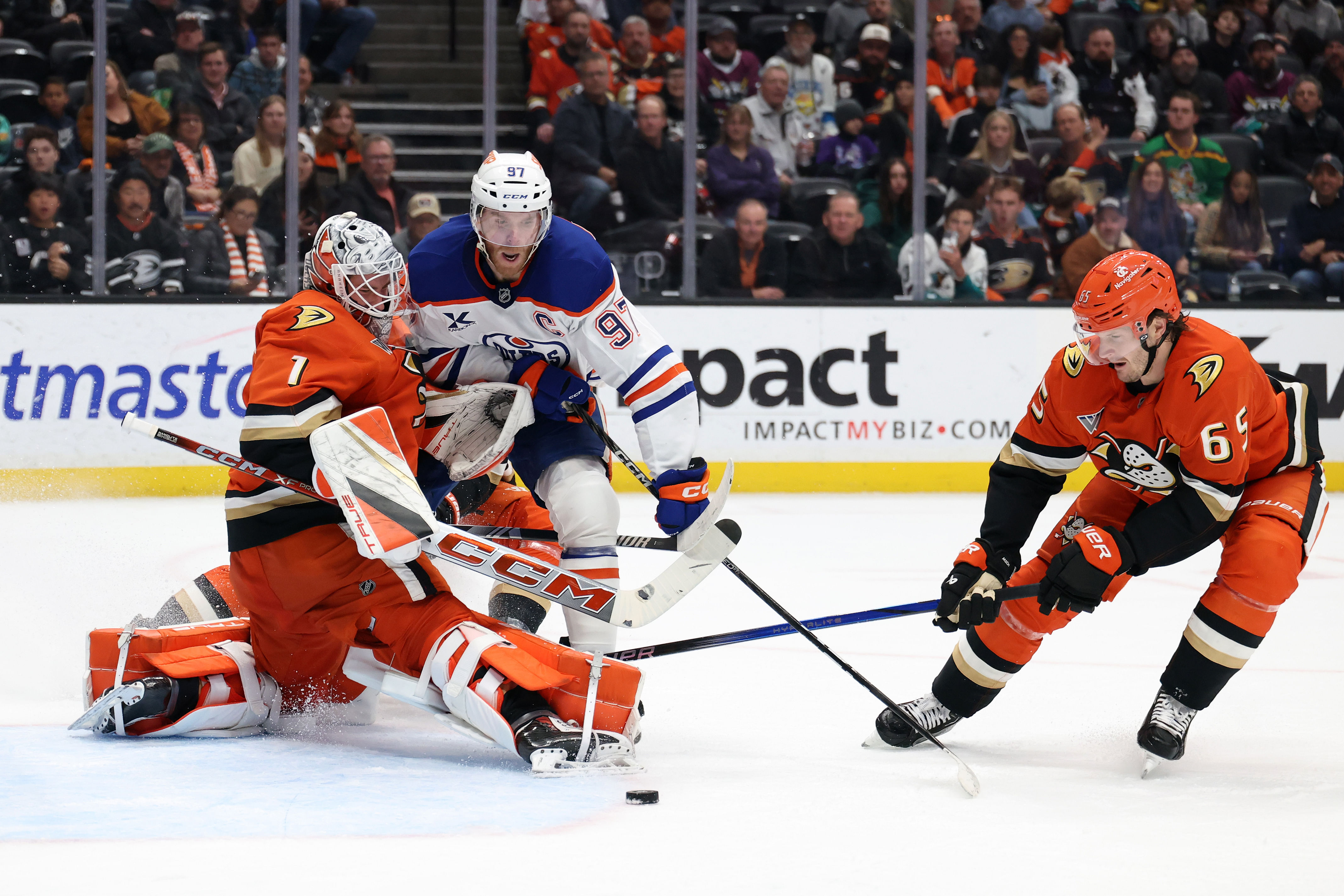 Edmonton Oilers center Connor McDavid (97) fights for the puck against Anaheim Ducks goaltender Lukas Dostal (1) and defenseman Jacob Trouba (65). (Credit: IMAGN)