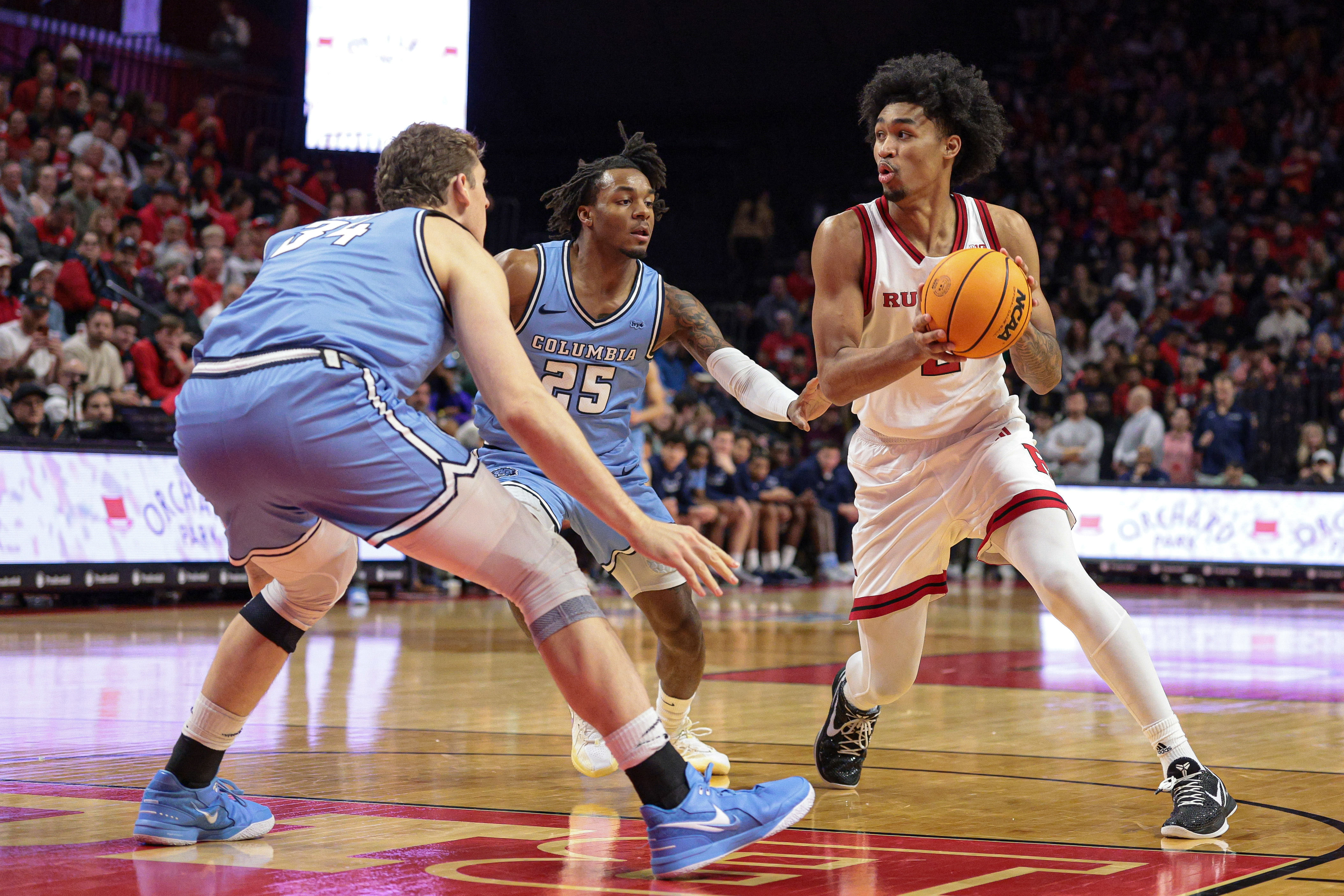 Rutgers Scarlet Knights guard Dylan Harper (#2) looks to pass as Columbia Lions guard Avery Brown (#25) and forward Jake Tavroff (#34) defend during the second half at Jersey Mike&#039;s Arena. Photo: Imagn