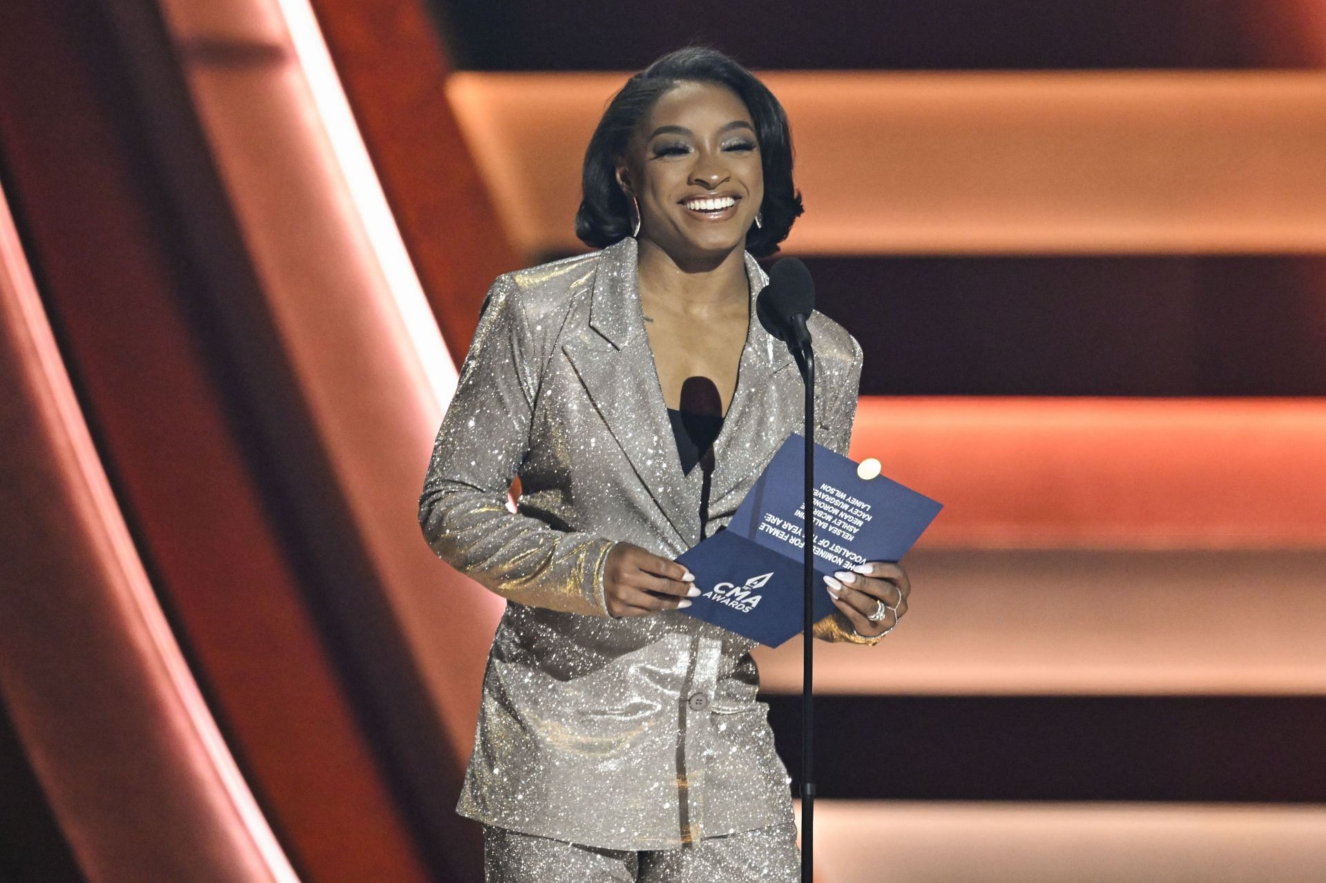 Simone Biles donning a classic grey blazer at the Bridgestone Arena during the 58th CMA Awards (Image via: Getty Images)