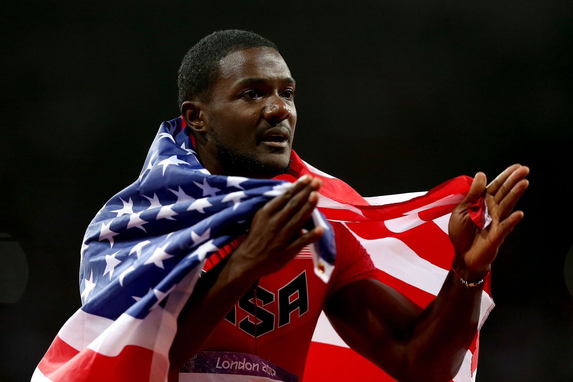 Gatlin celebrates with the US flag after clinching a bronze medal in the 100m event during the 2012 Olympics (Image via: Getty Images)