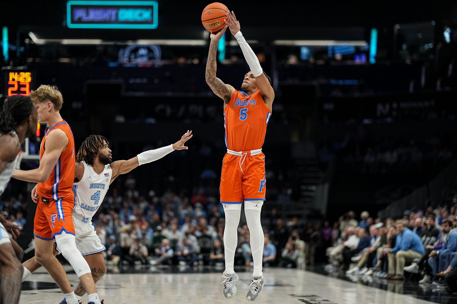 Will Richard (#5) of the Florida Gators makes a three-point basket over RJ Davis (#4) of the North Carolina Tar Heels in the first half of their game during the Jumpman Invitational. Photo: Getty