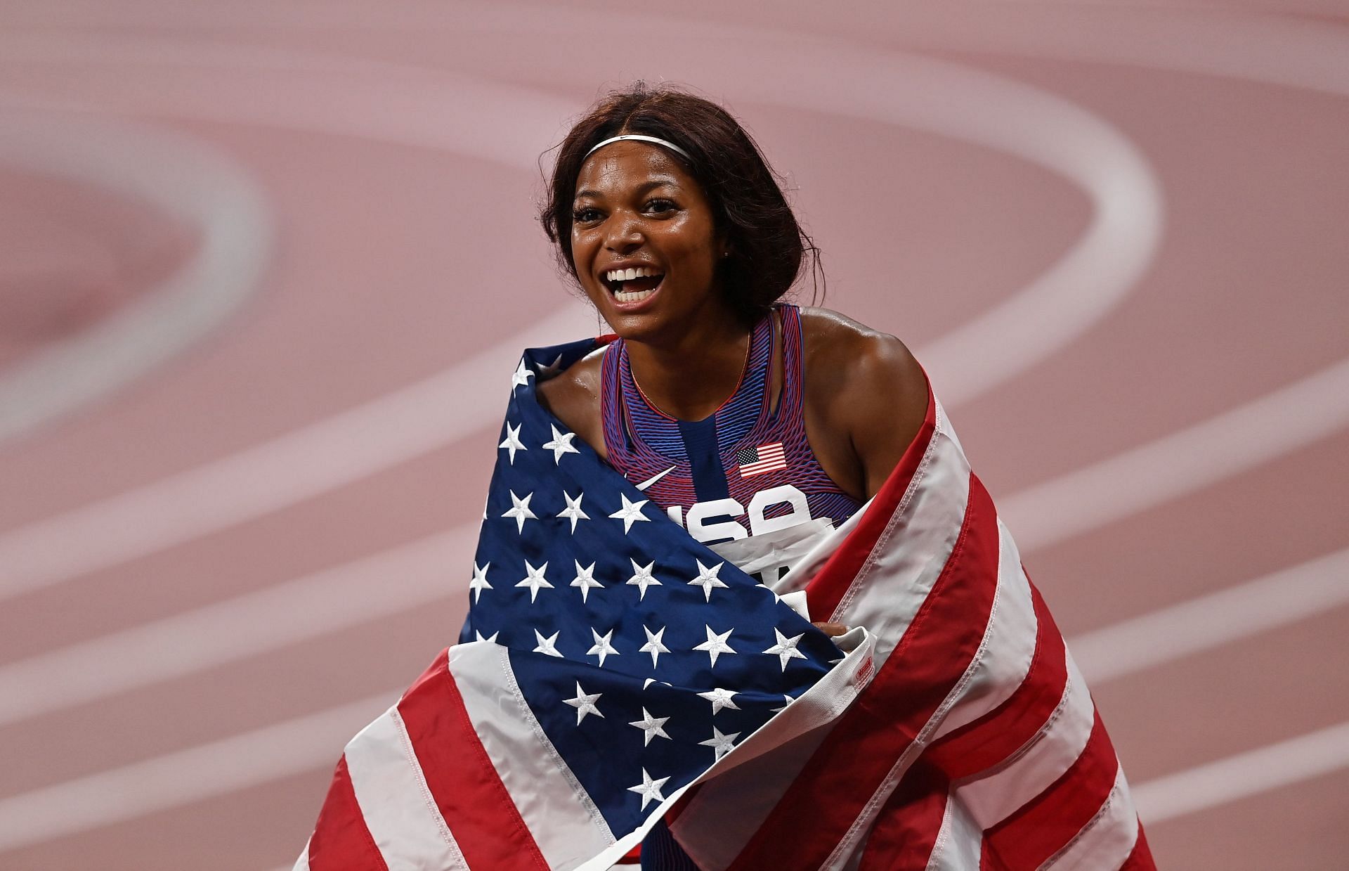 Thomas celebrating with the United States flag after her 200m bronze medal victory on the 11th day of the 2020 Tokyo Olympics (Image via: Getty Images)