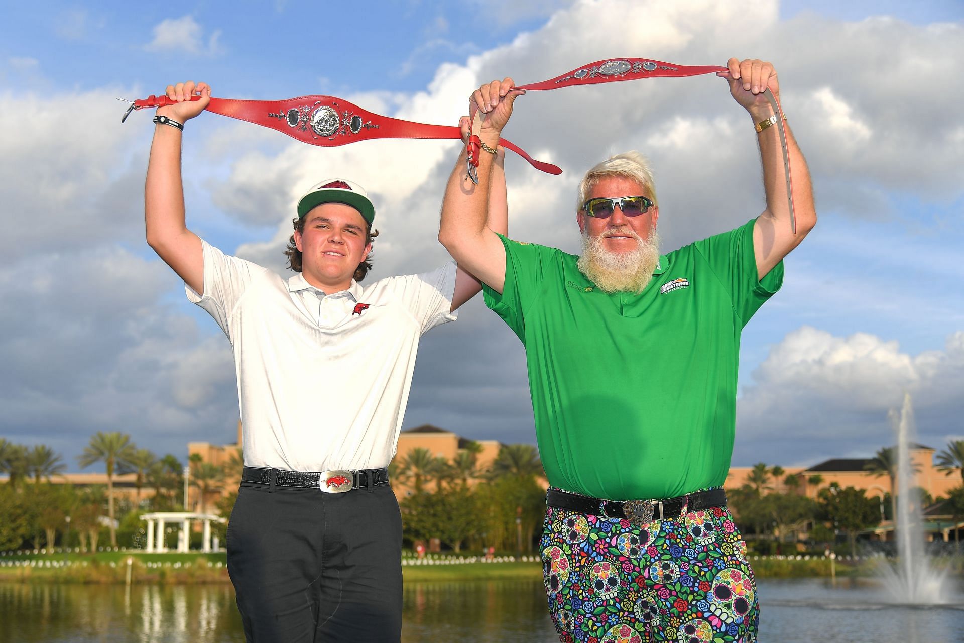 John Daly II and John Daly hold the belts on the 18th green after winning the 2021 PNC Championship (Image Source: Getty)