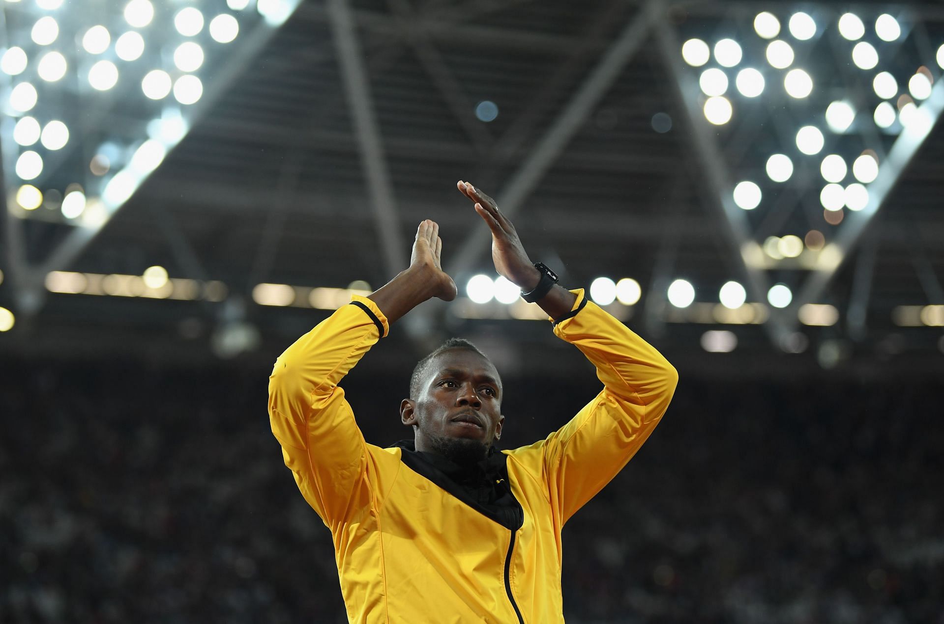 Bolt cheering on in a yellow track uniform during the 10th day of the 2017 World Athletics Championships (Image via: Getty Images)