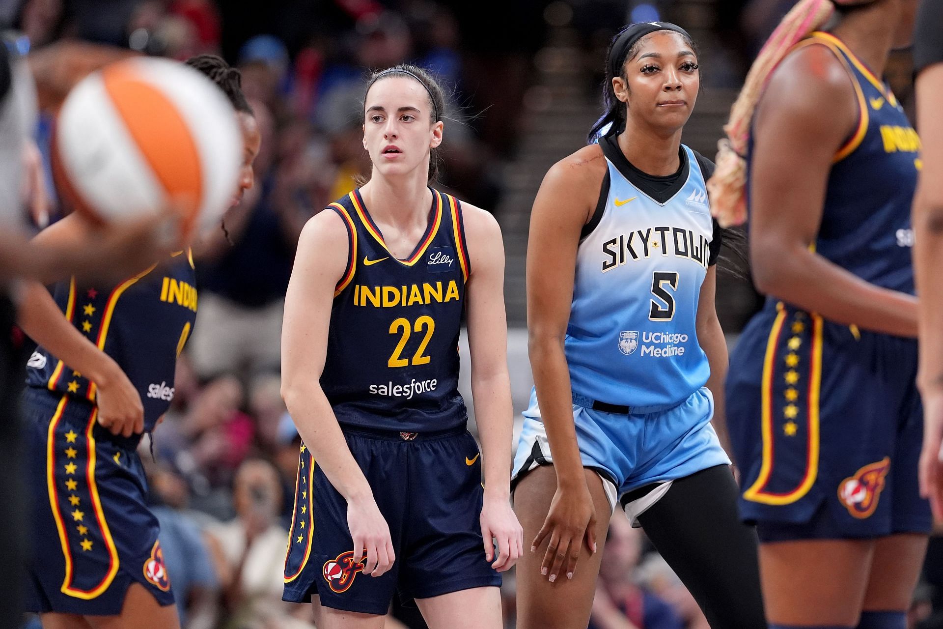 Caitlin Clark #22 of the Indiana Fever and Angel Reese #5 of the Chicago Sky look on during a game at Gainbridge Fieldhouse (Credits: Getty)