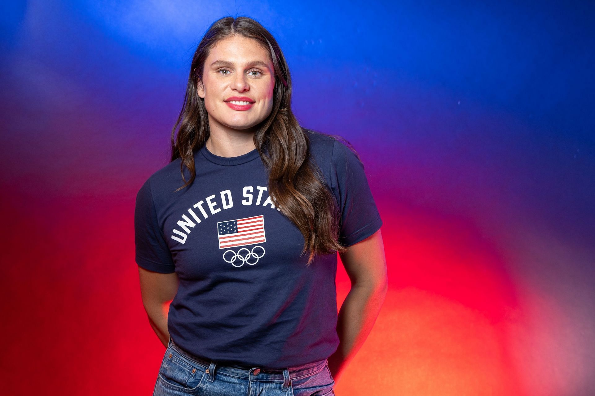 Maher posing in a blue shirt and jeans during the Team USA Media Summit (Image via: Getty Images)