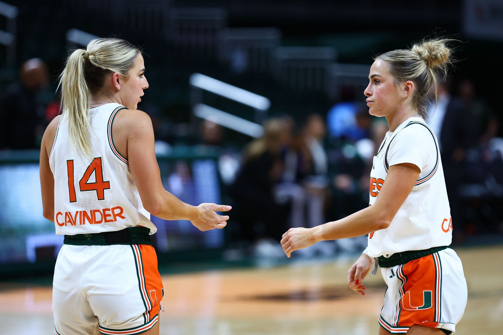 Haley Cavinder (#14) and Hanna Cavinder (#15) of the Miami Hurricanes speak on the court prior to the second half of the game against the Jacksonville Dolphins. Photo: Getty