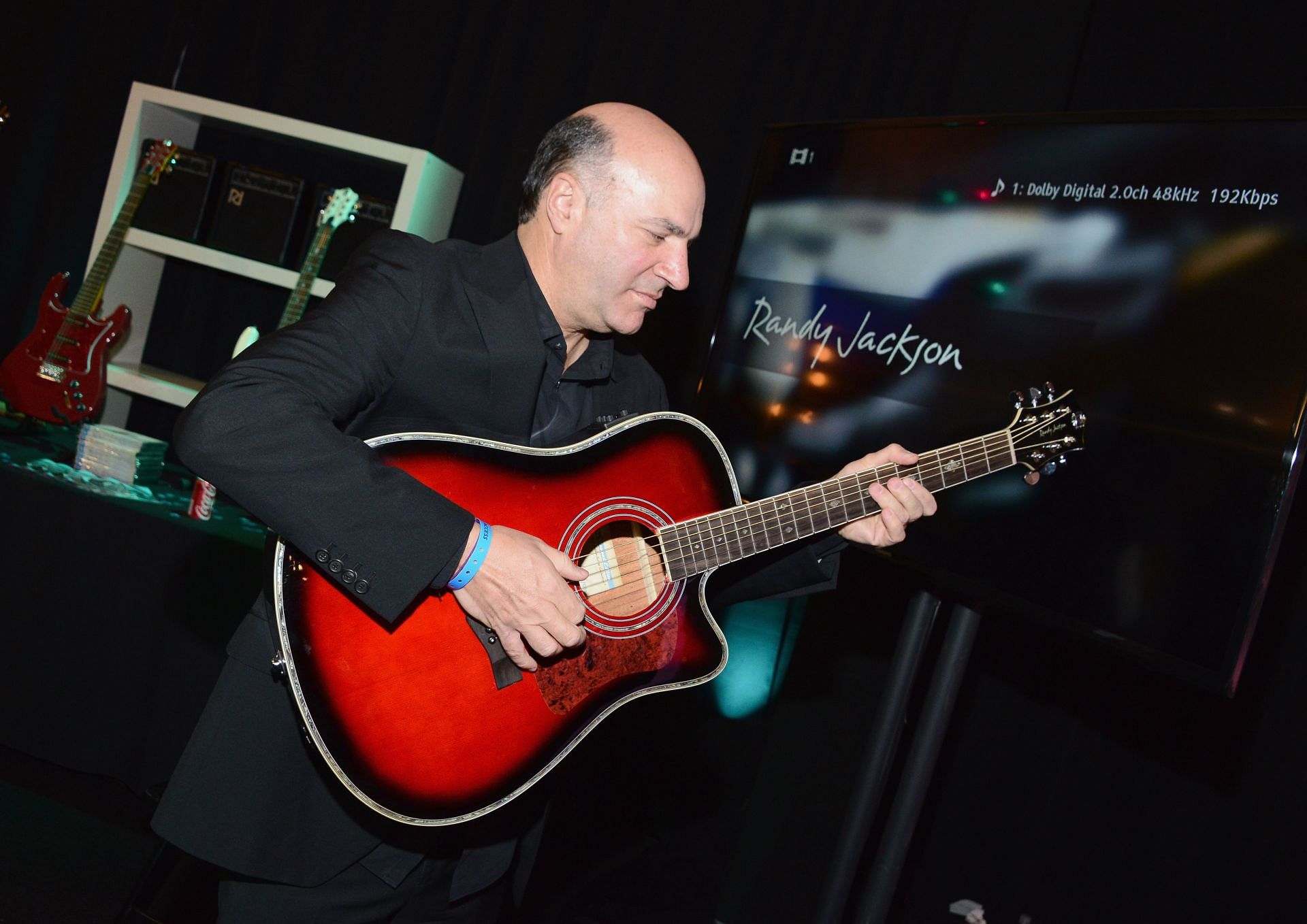 Kevin O&#039;Leary poses with Randy Jackson&#039;s &quot;True Faith Guitar Collection&quot; for HSN (Image via Getty)